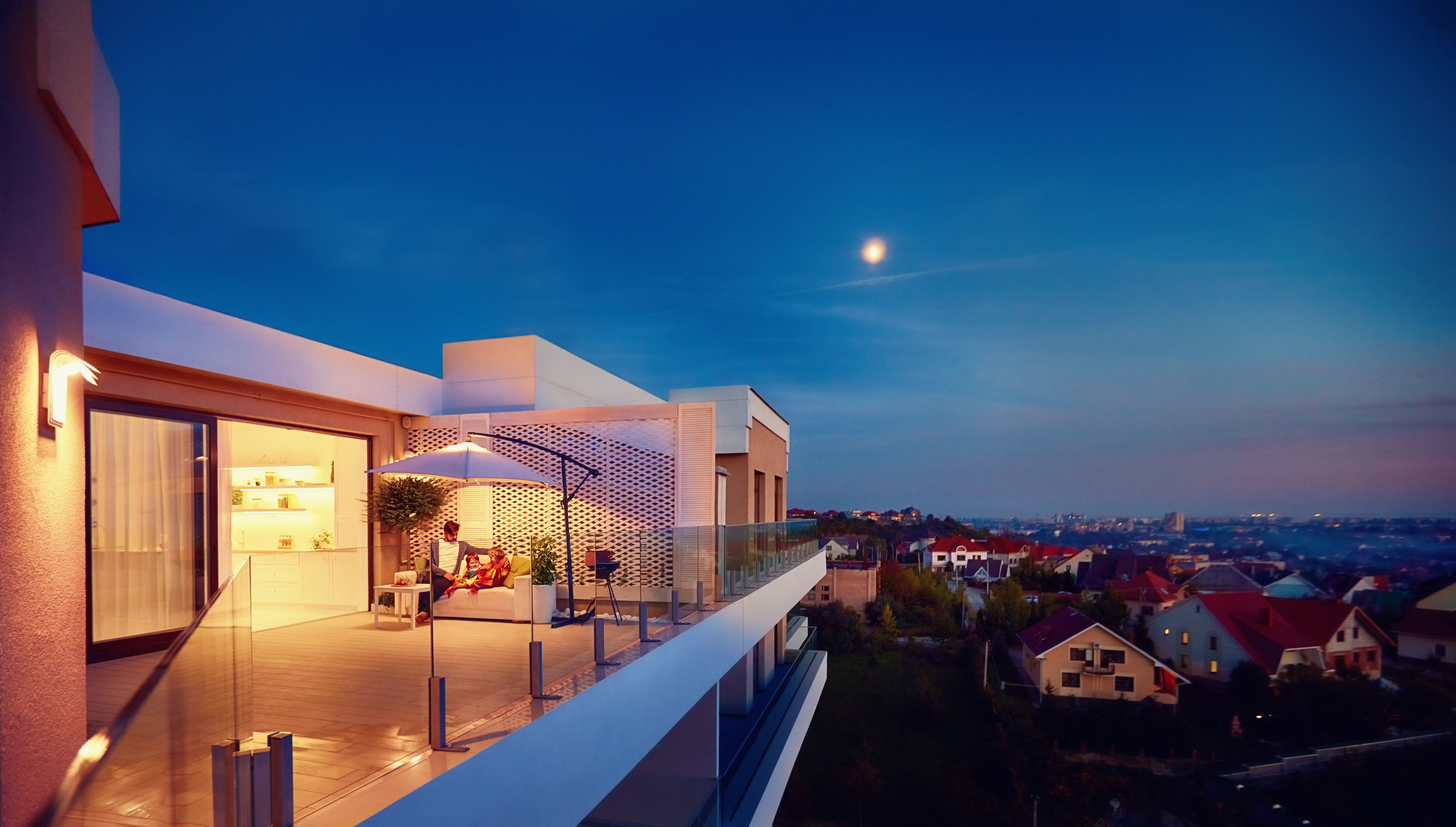 family relaxing on roof top patio with evening city view family relaxing on roof top patio with evening city view
