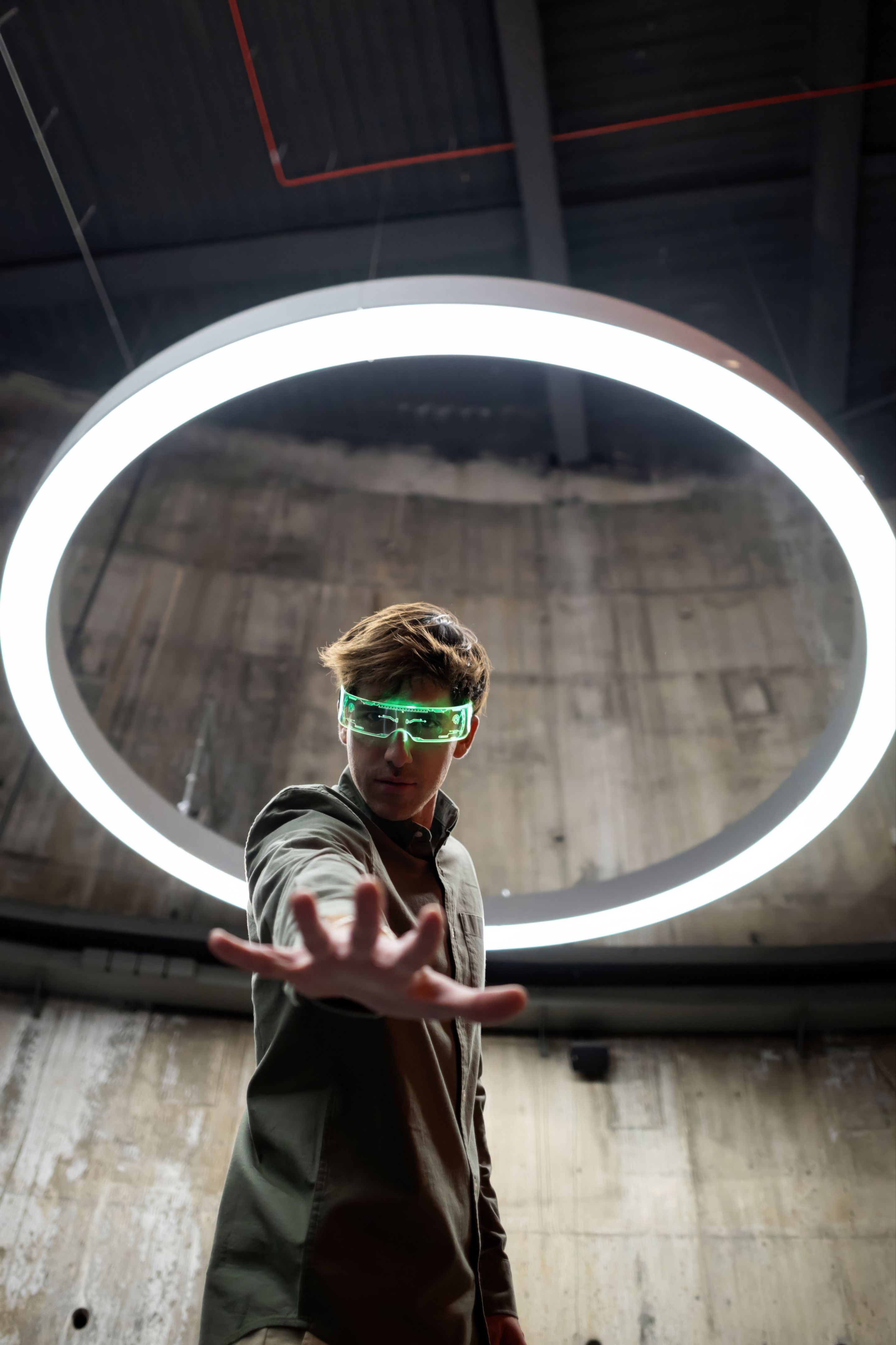 Software developer reaching out with futuristic glasses and neon light circle