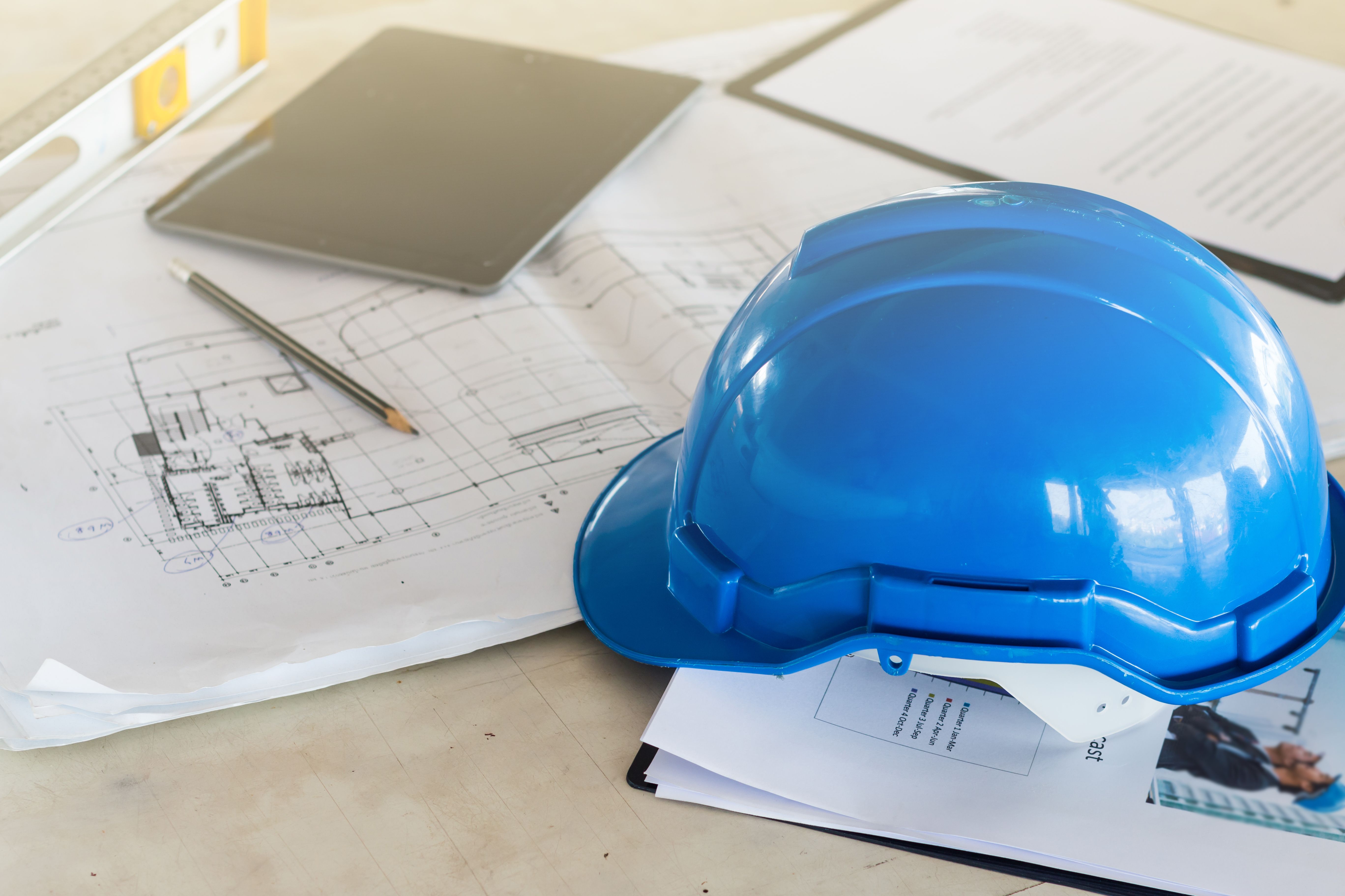 The safety helmet and the blueprint on table at construction site