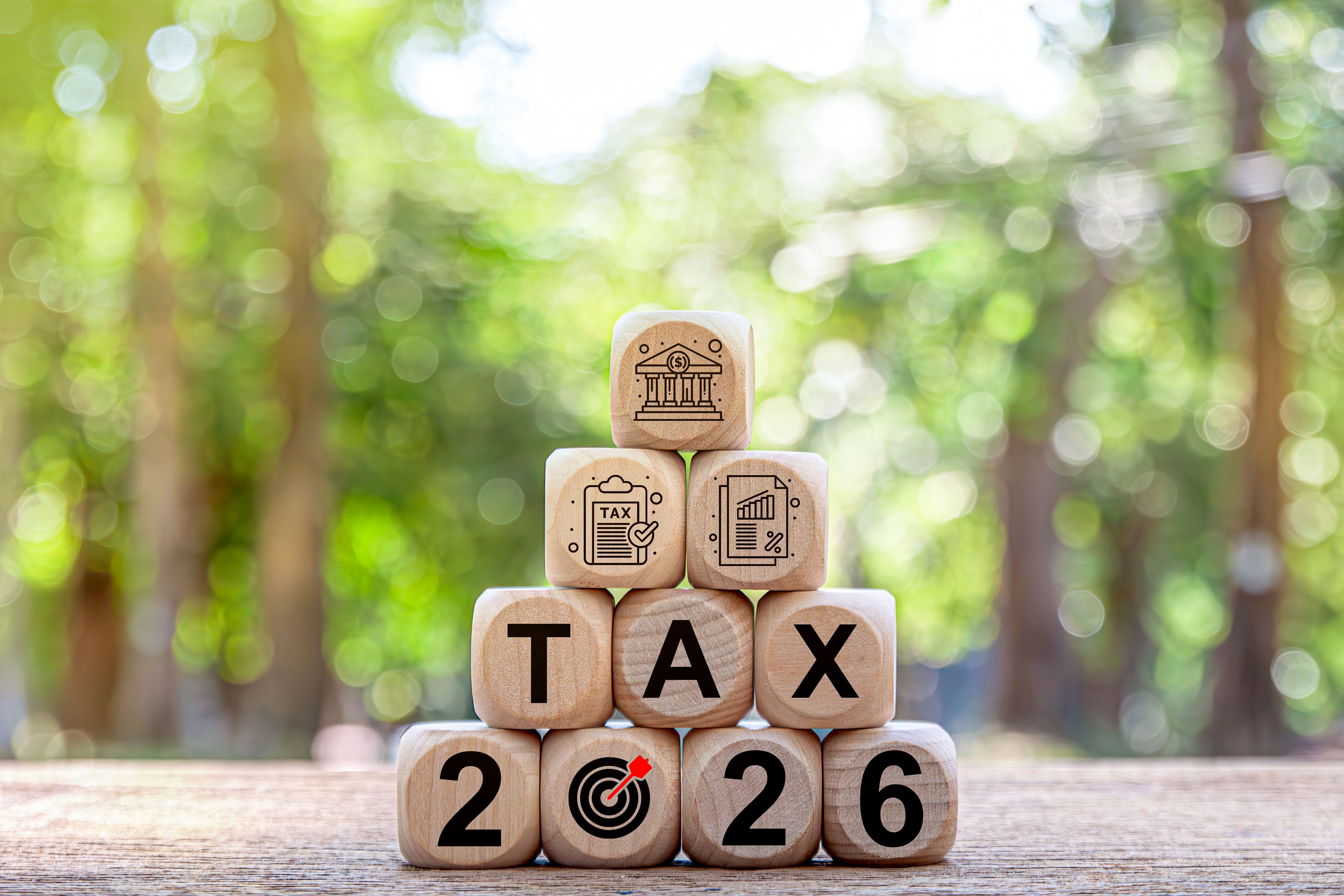 Tax and Vat 2026 Concept.Tax wooden letters on wooden cubes with 2026 on coins. income tax online return form for payment. Expenses, account, VAT, pay