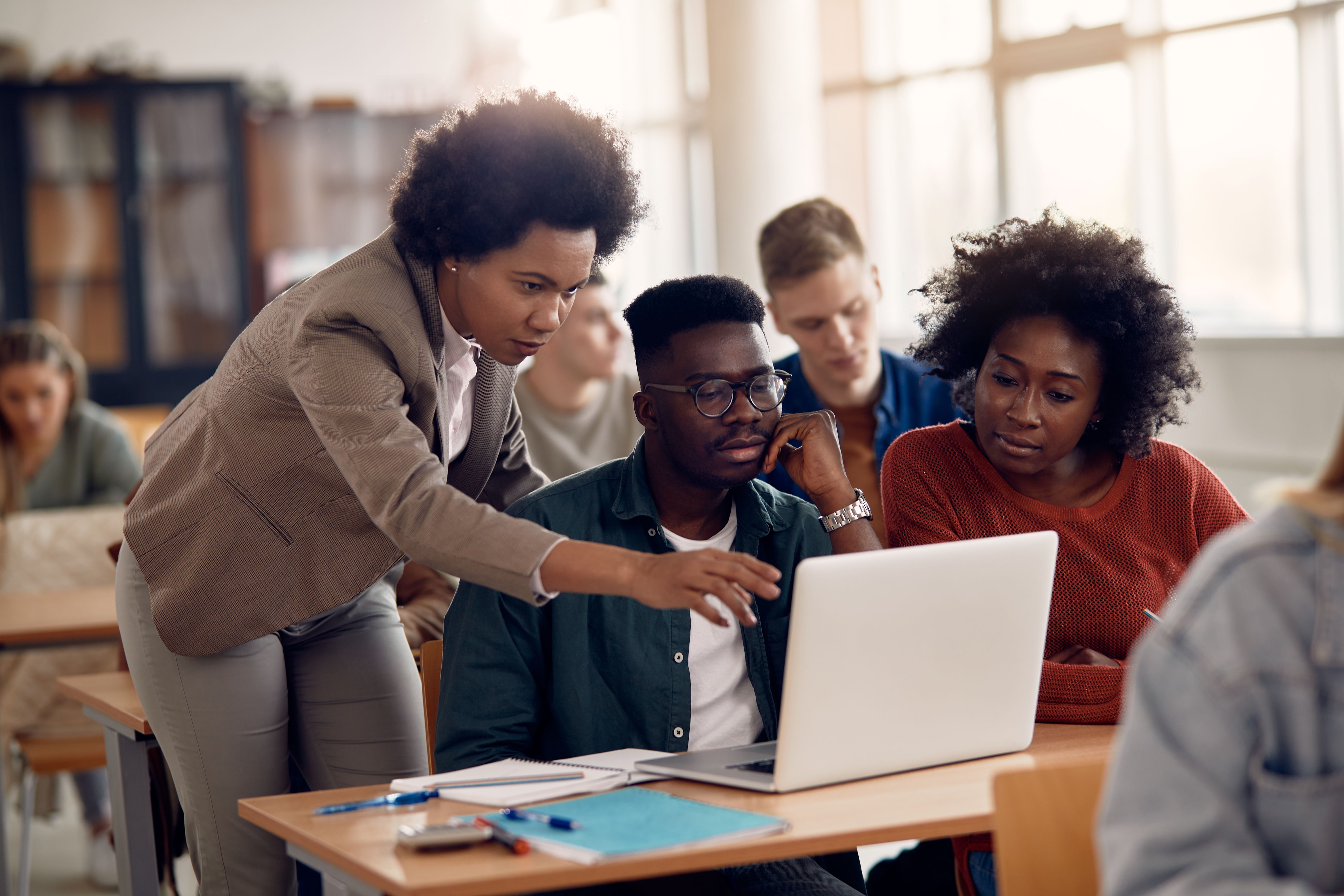African Americans college students e-leaning with their teacher during a class. African Americans college students e-leaning with their teacher during a class.