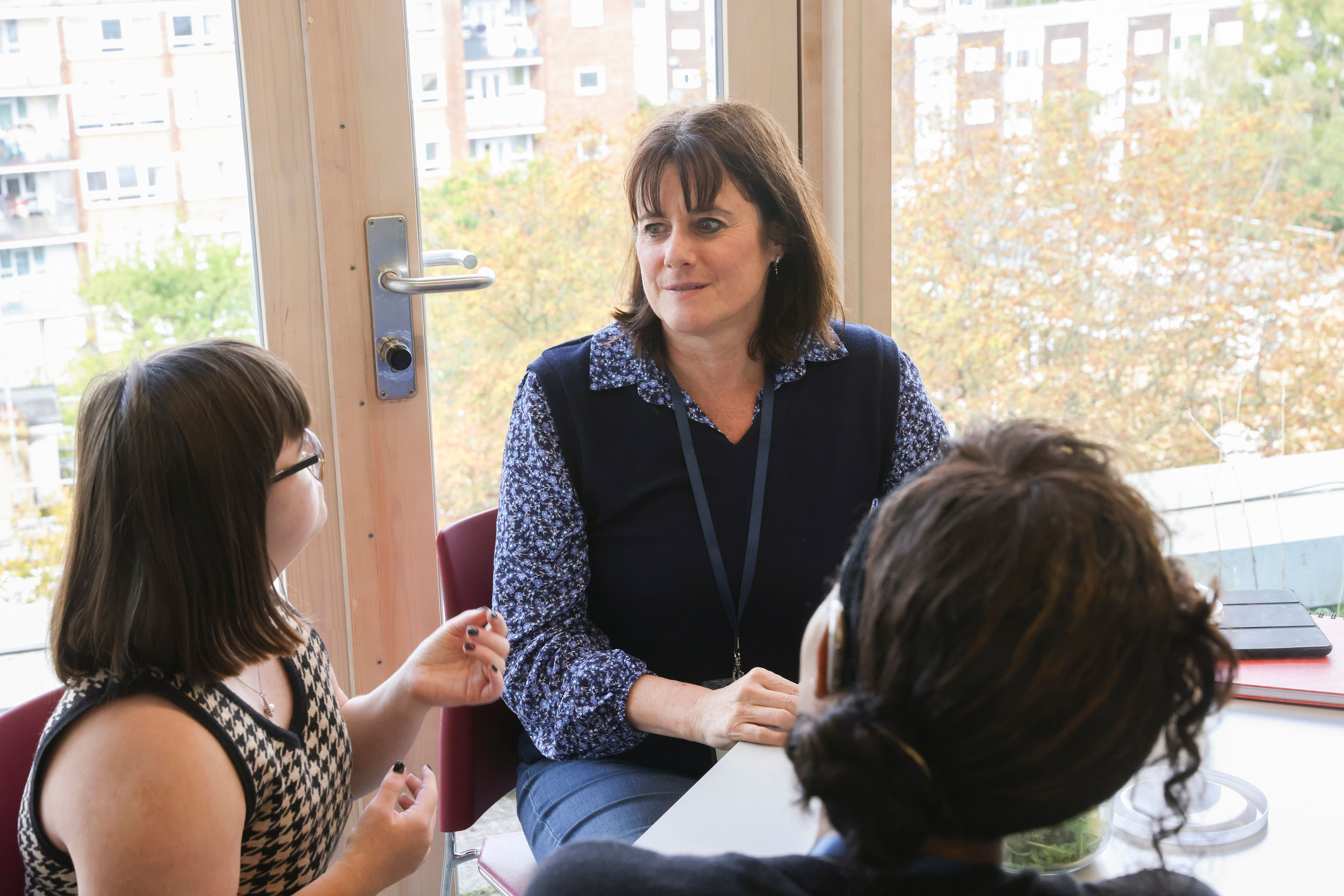 Women talking at table in office