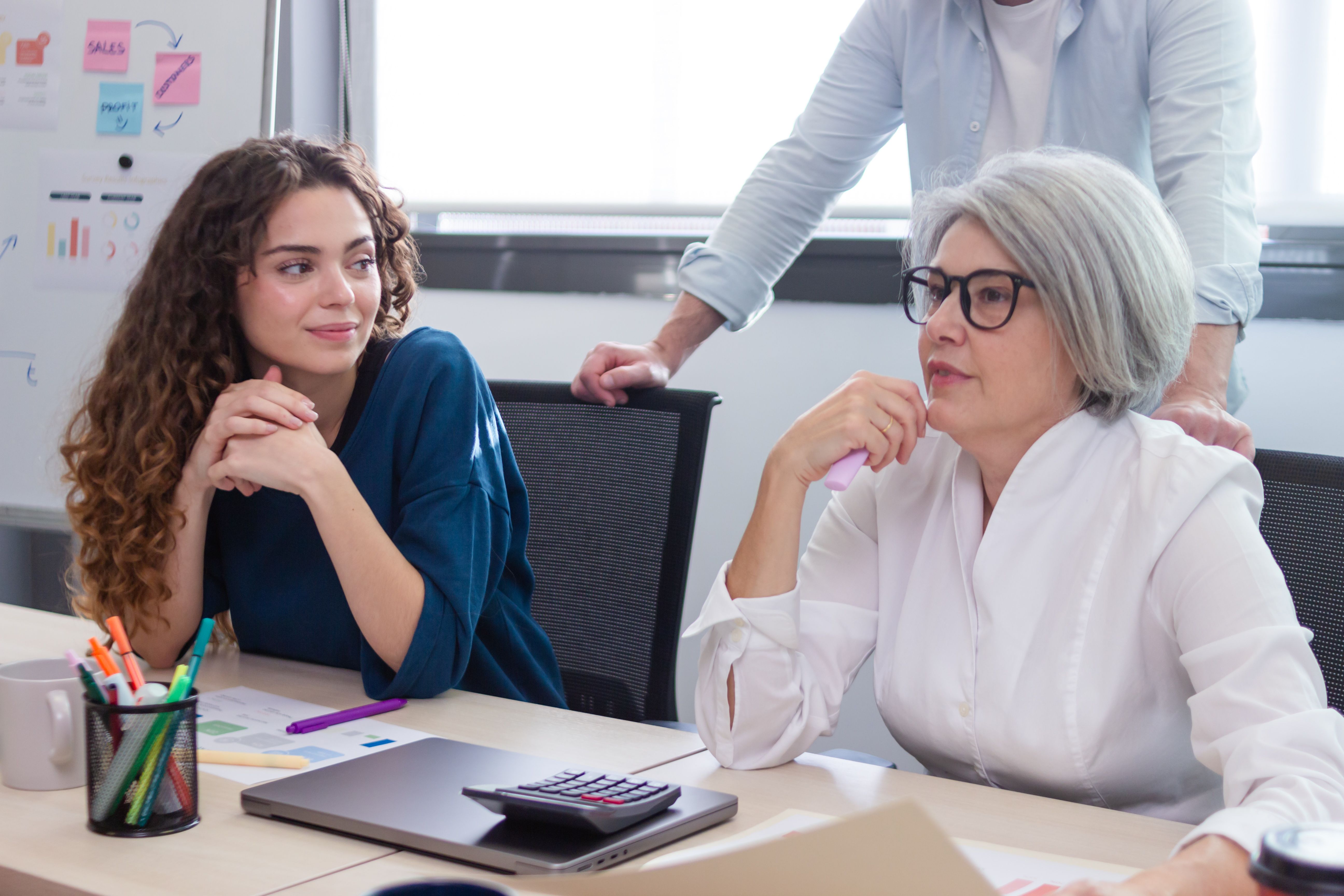 Two businesswomen and a businessman working together in a modern office