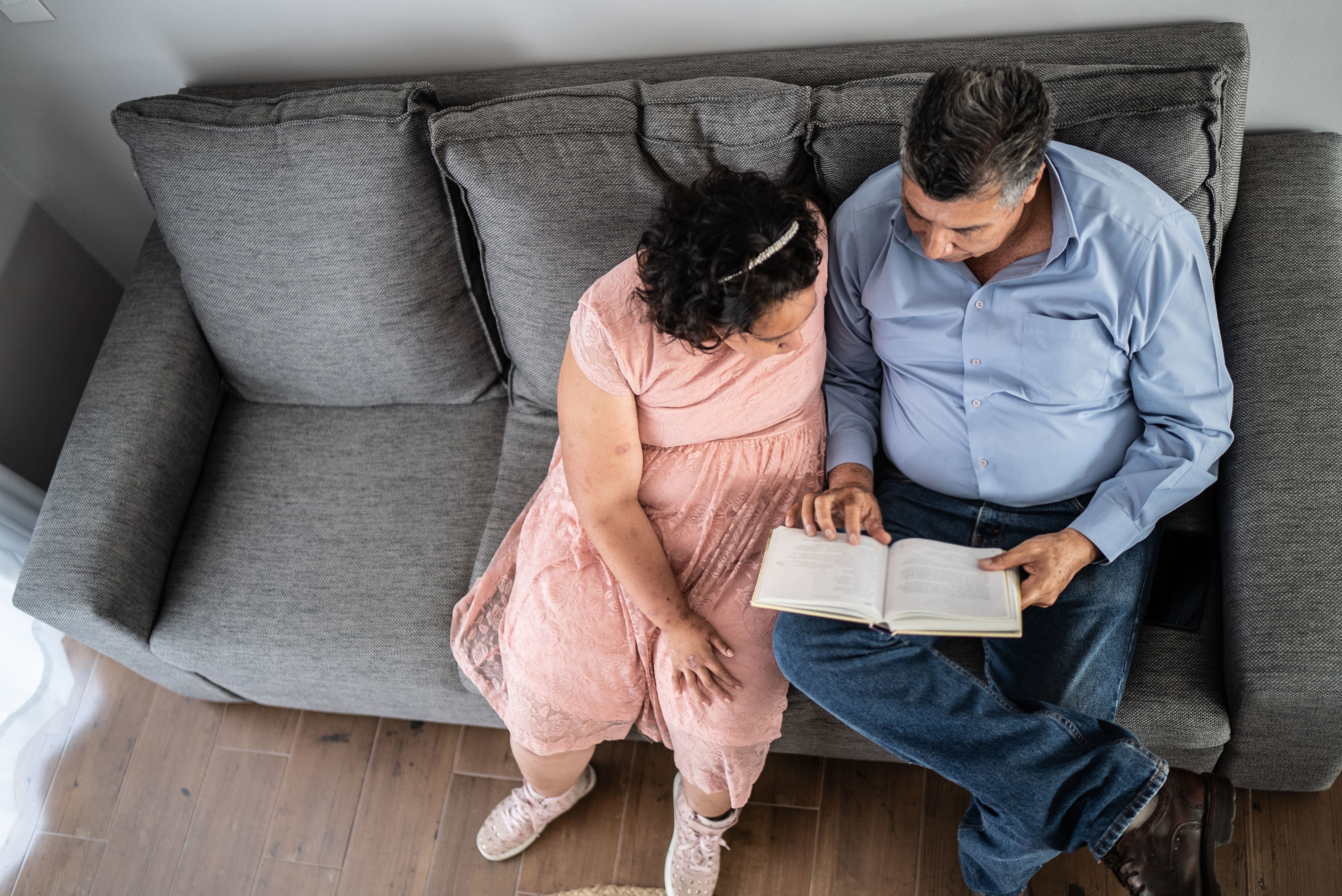 Father and psychomotor Intellectual disability daughter reading a book at home