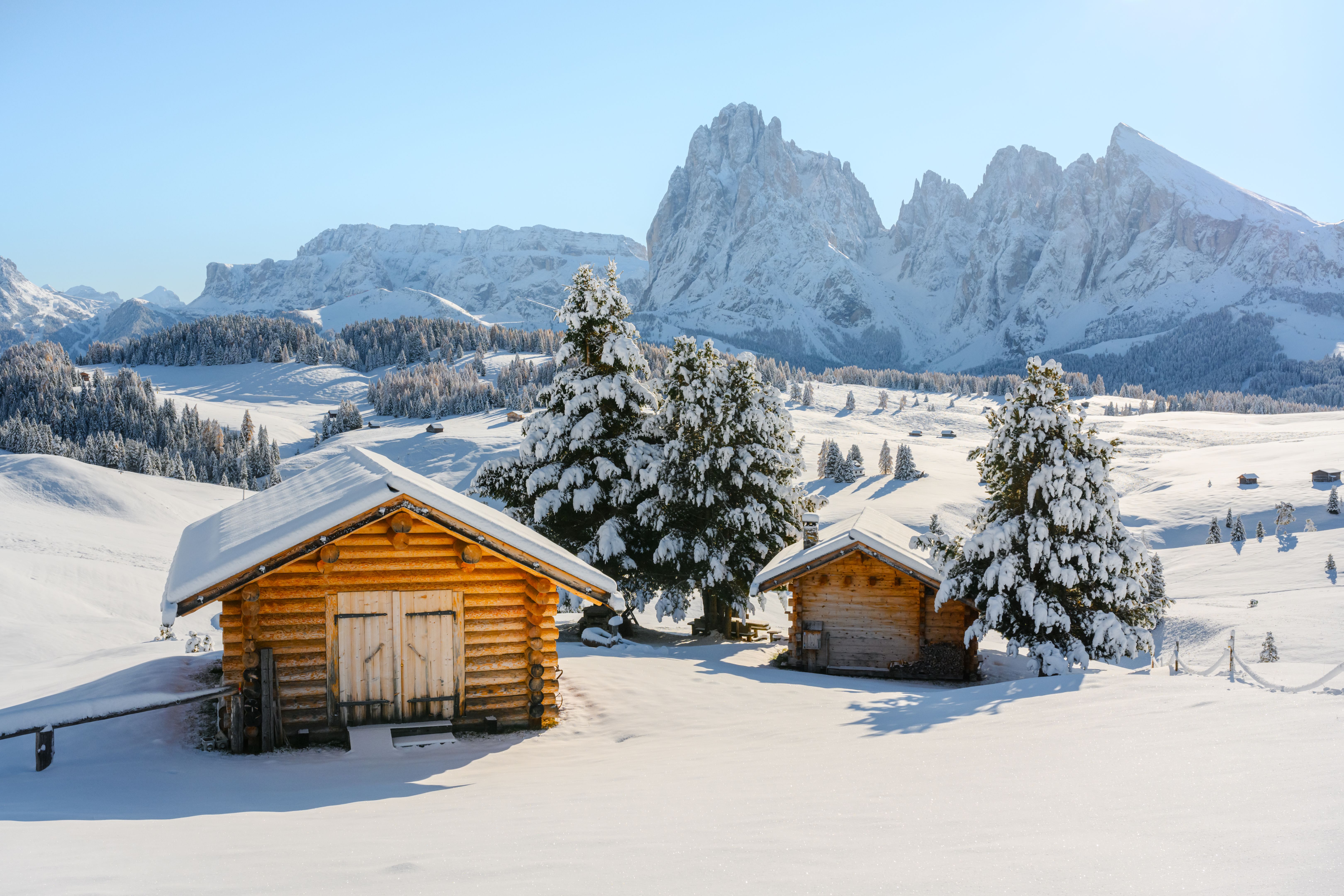 Picturesque landscape with cozy wooden log cabin on meadow Alpe di Siusi
