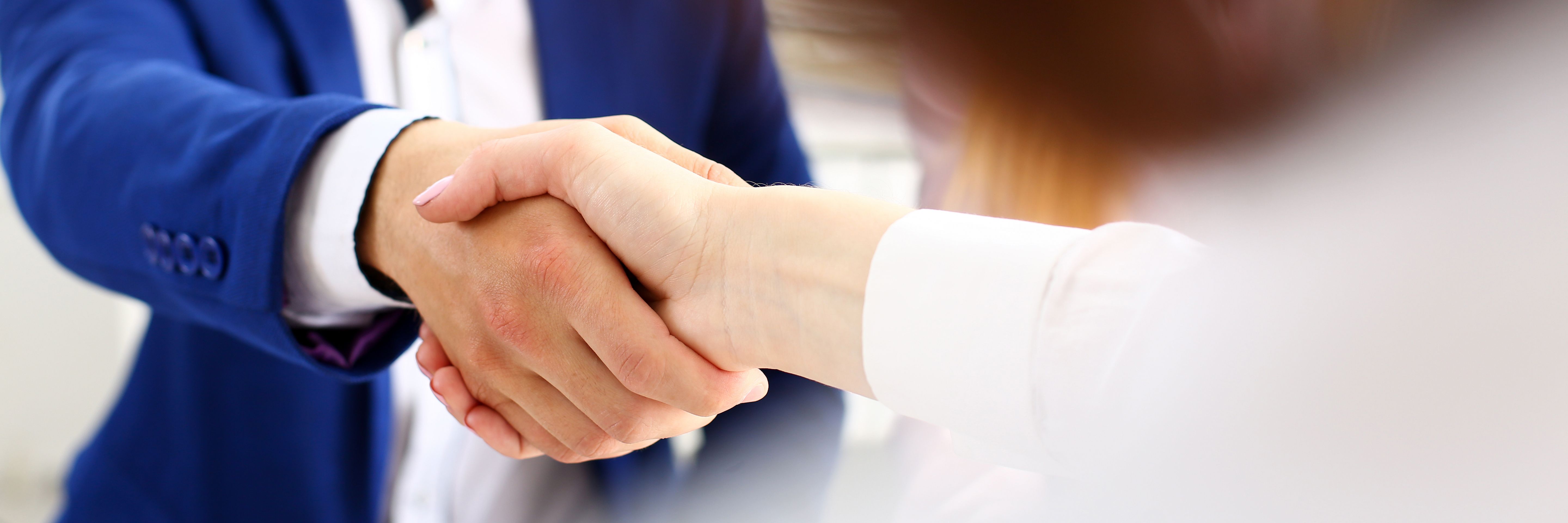 Man in suit shake hand as hello in office closeup