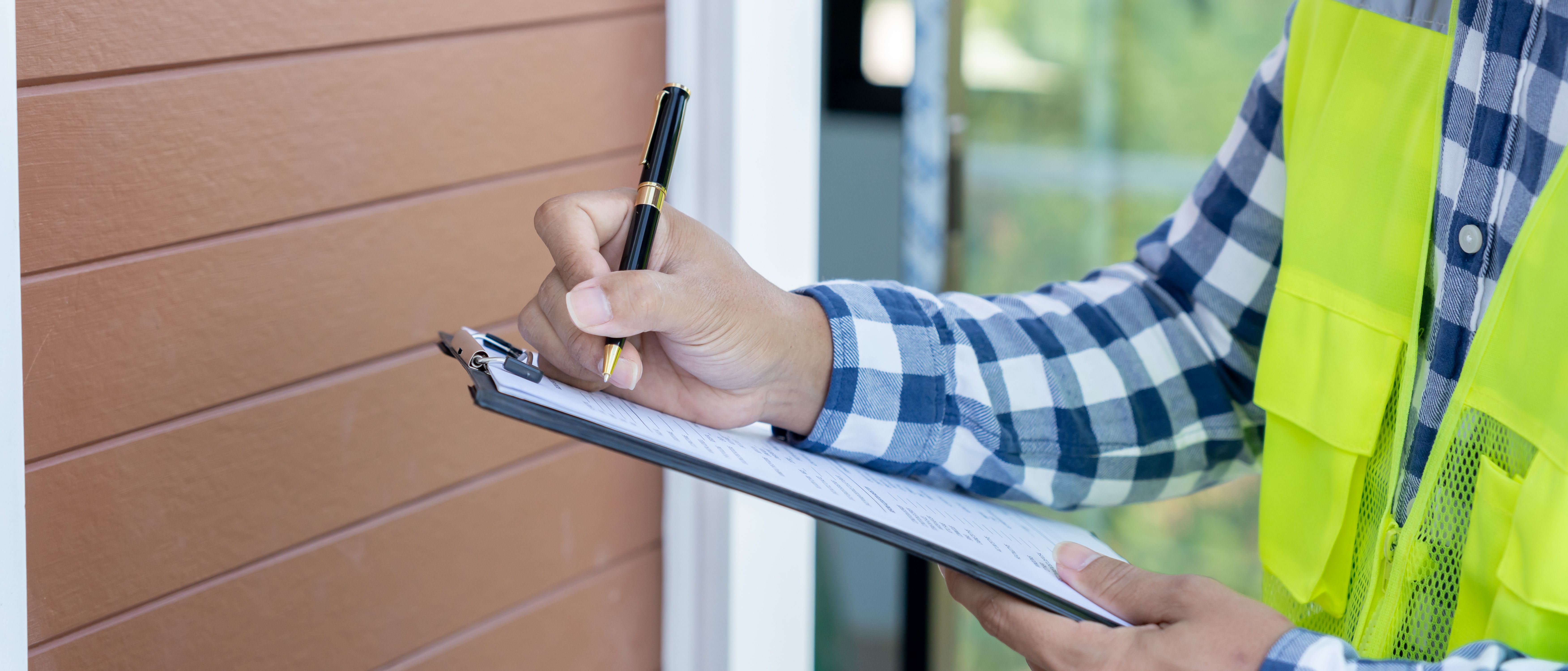 inspector or engineer is inspecting construction and quality assurance new house using a checklist. Engineers or architects or contactor work to build the house before handing it over to the homeowner