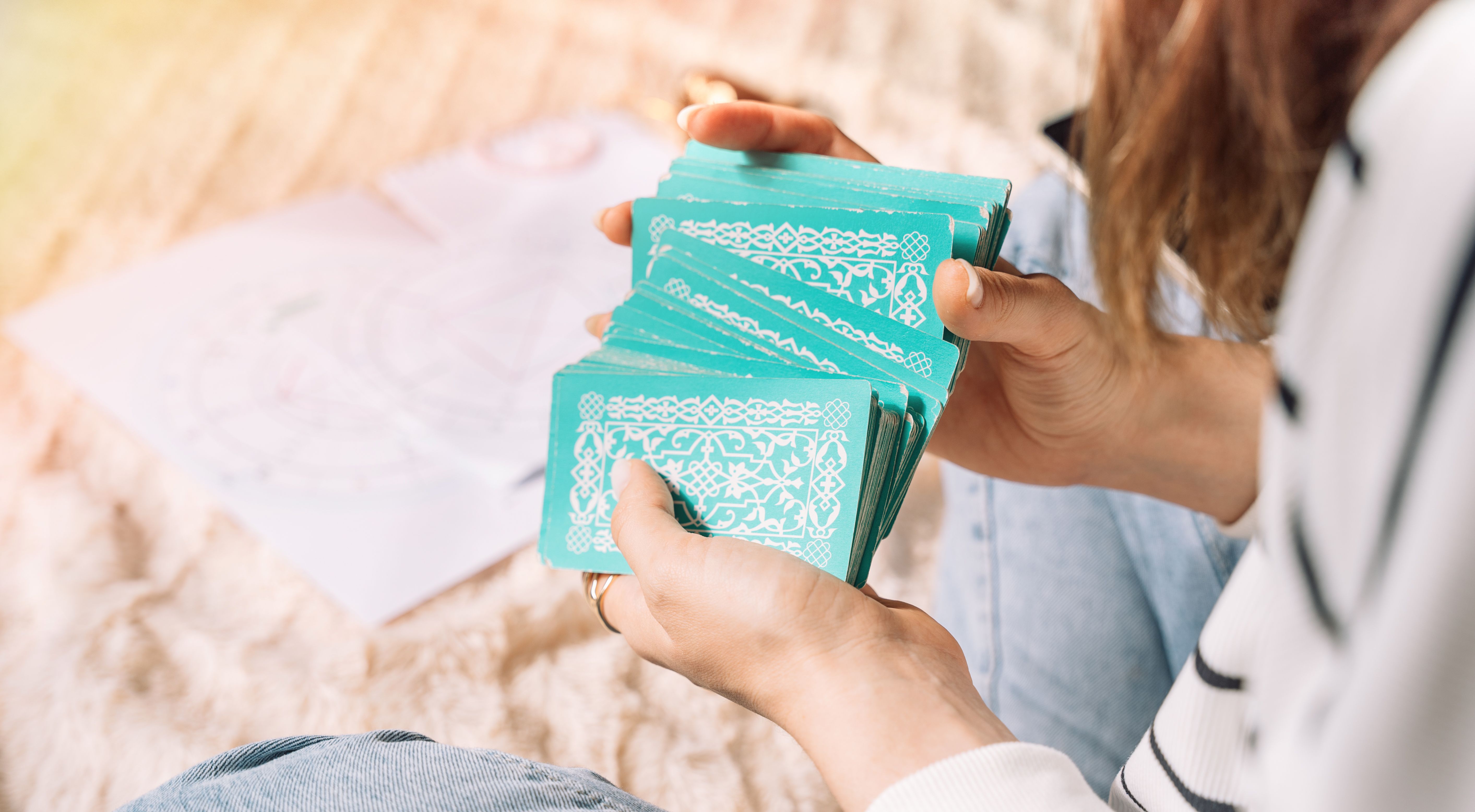Lady shuffling tarot cards with green cover