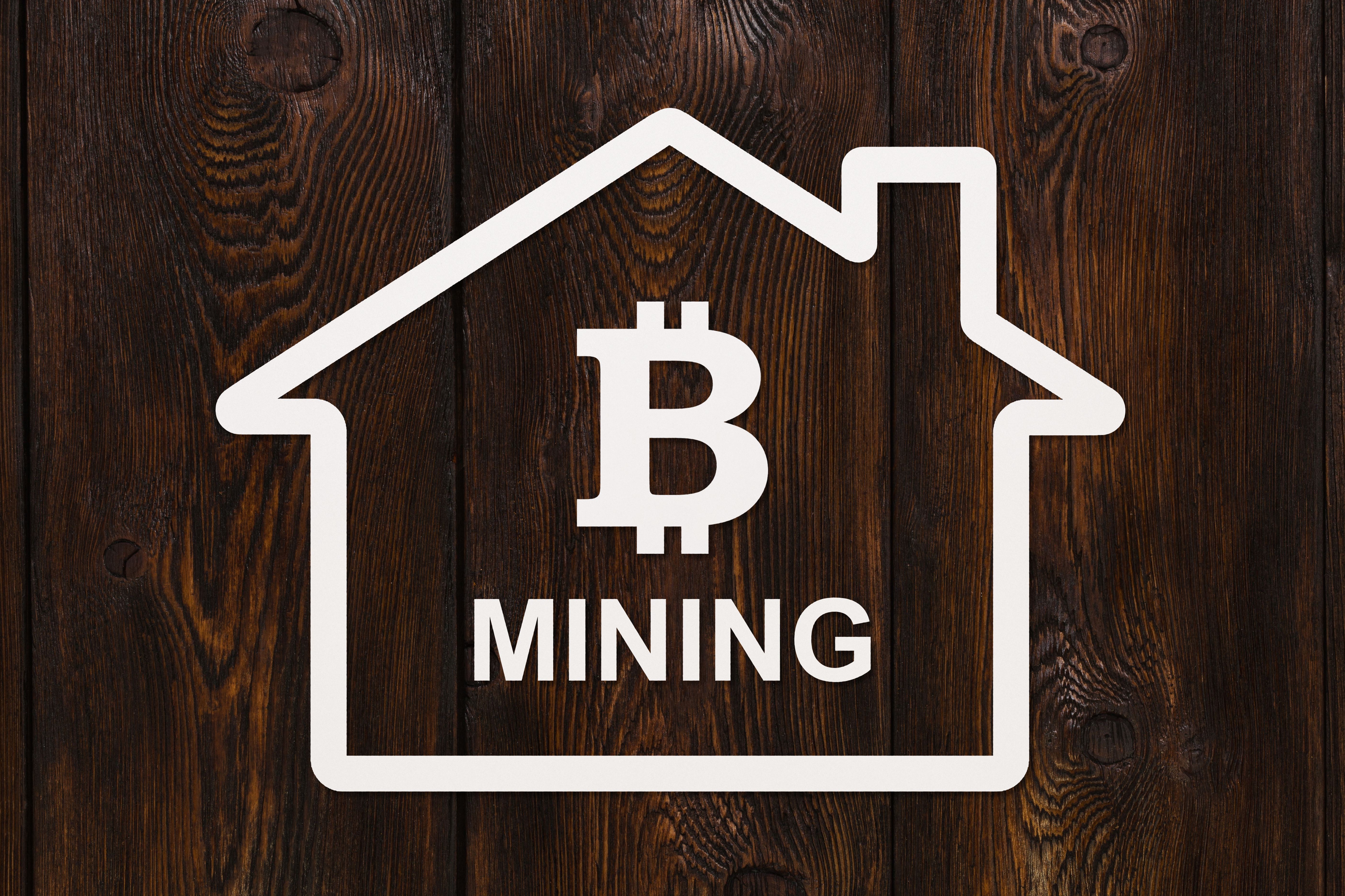 Paper house with bitcoin inside and text MINING. Abstract concept