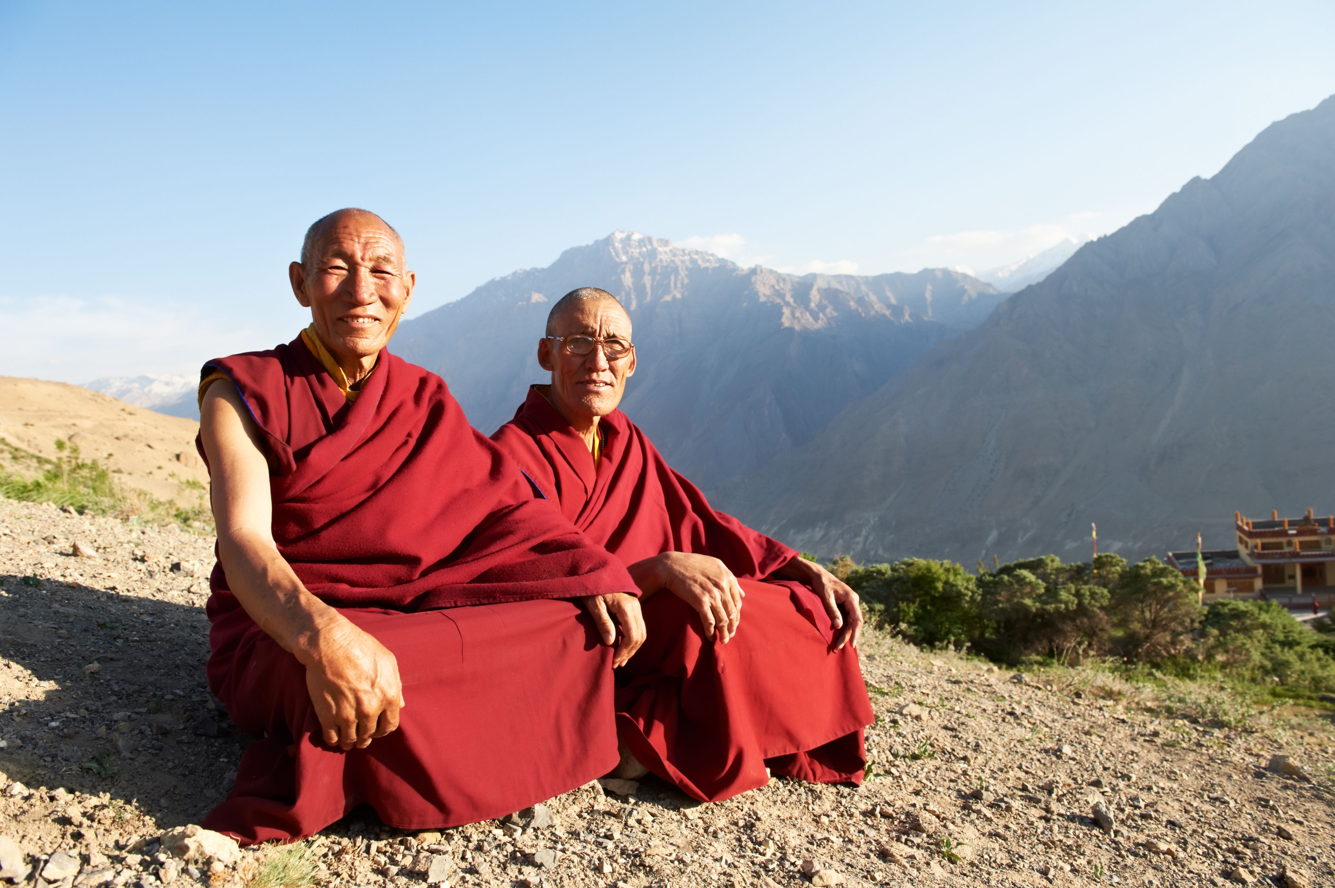 Two Indian Tibetan monks are sitting on a mountain