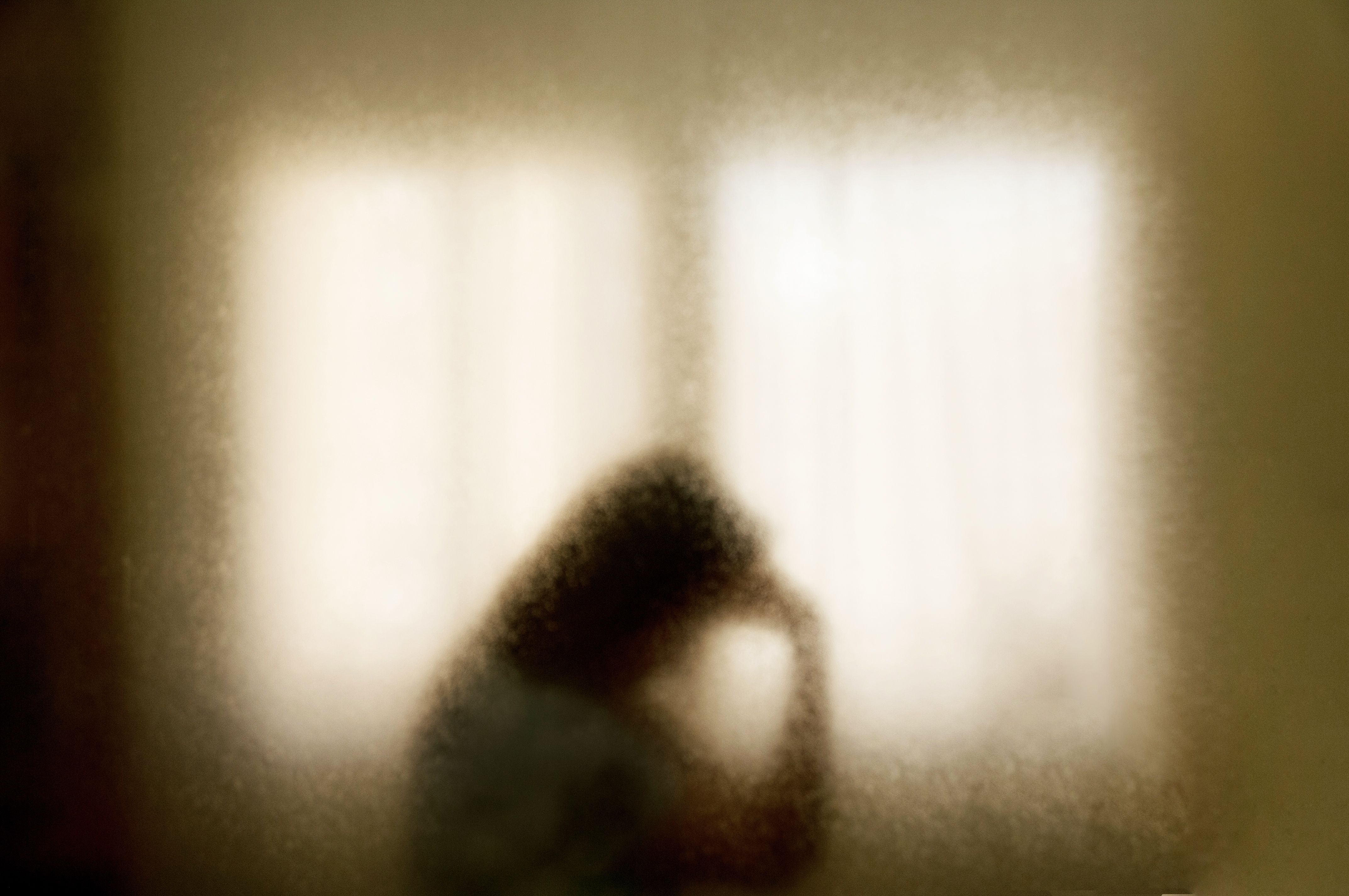 Blurred silhouette of a woman in emotional distress .