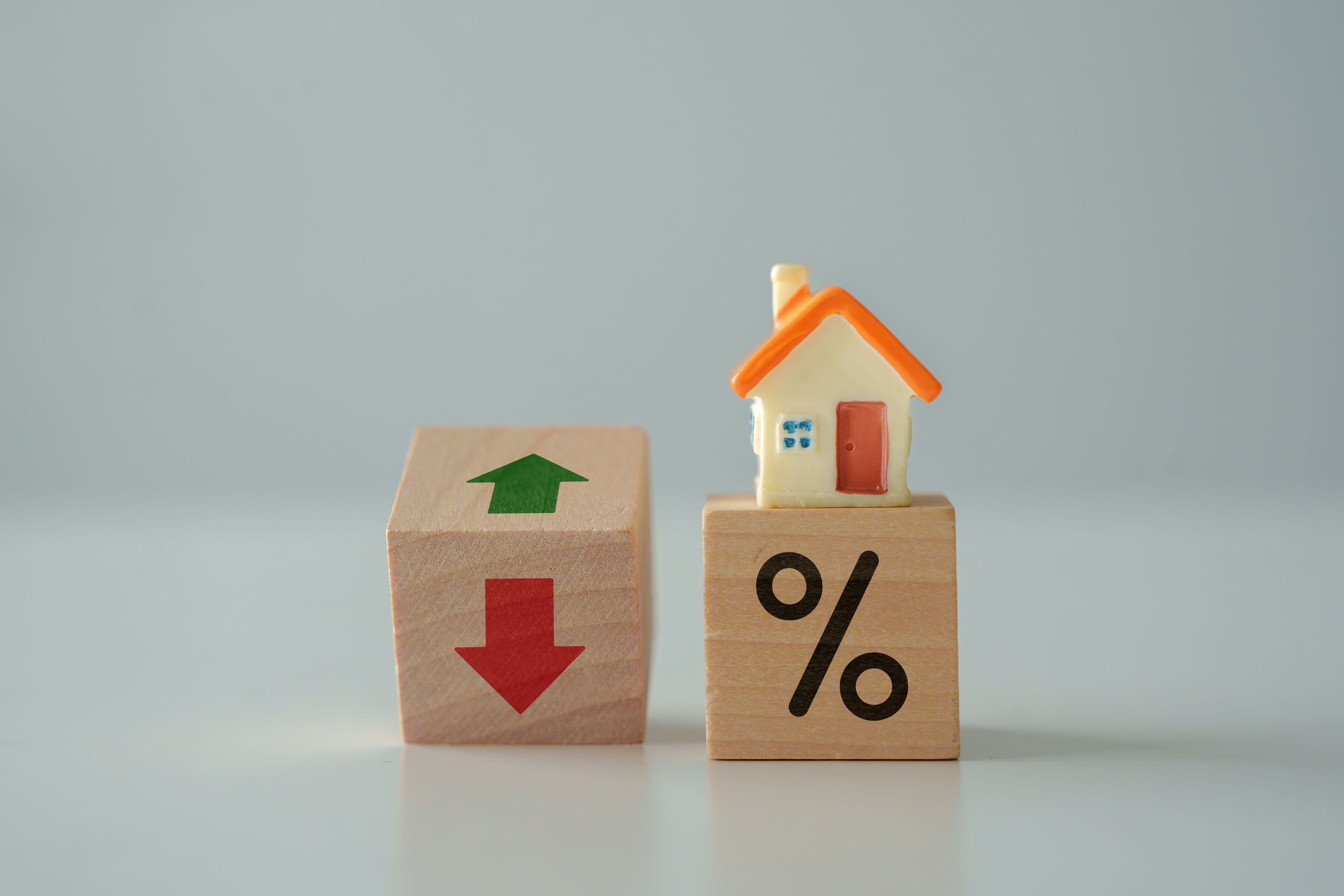 House model and percentage sign with arrow up and down. Housing finance and mortgage rates concept.