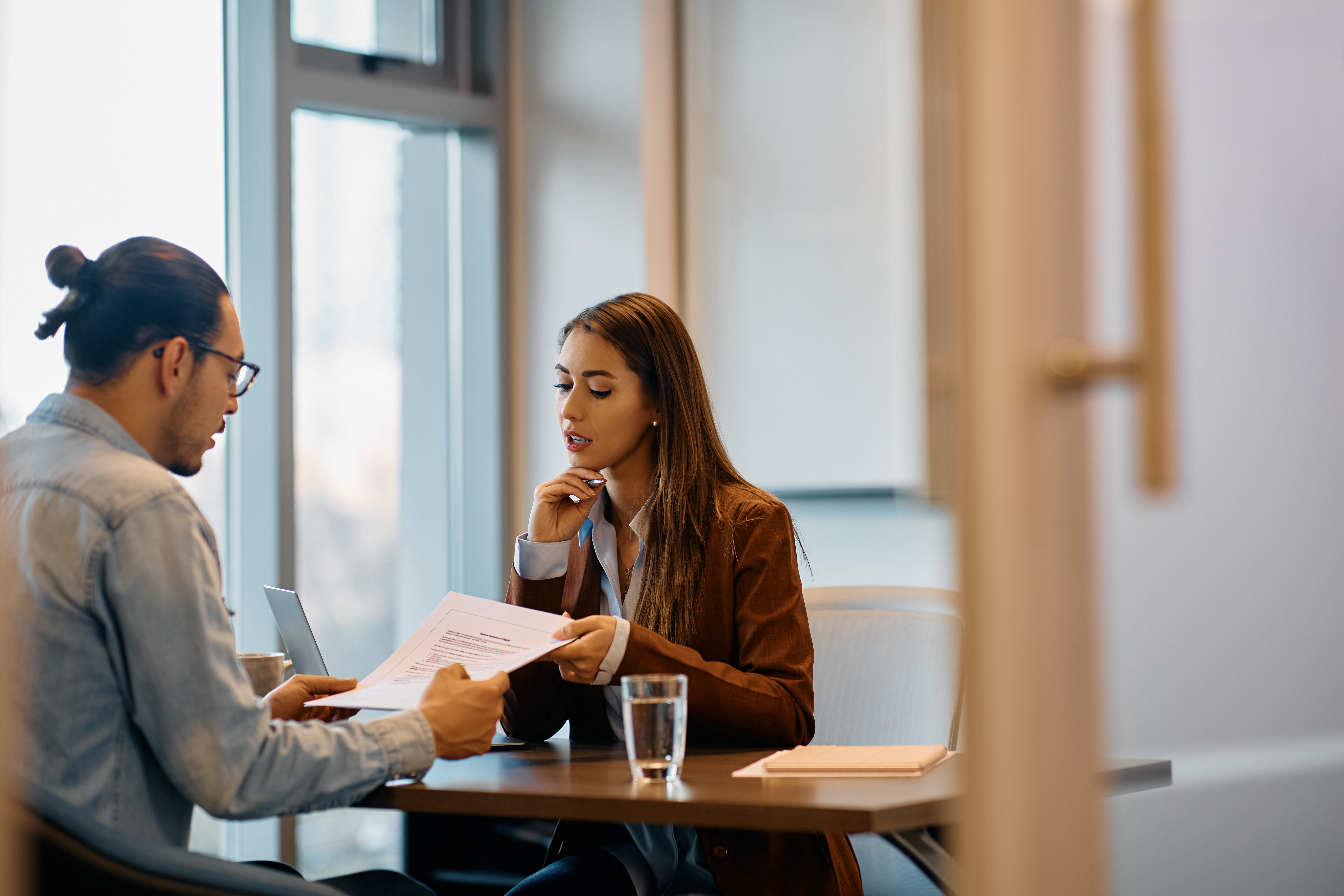 Human resource manager going through documents with male candidate in the office.