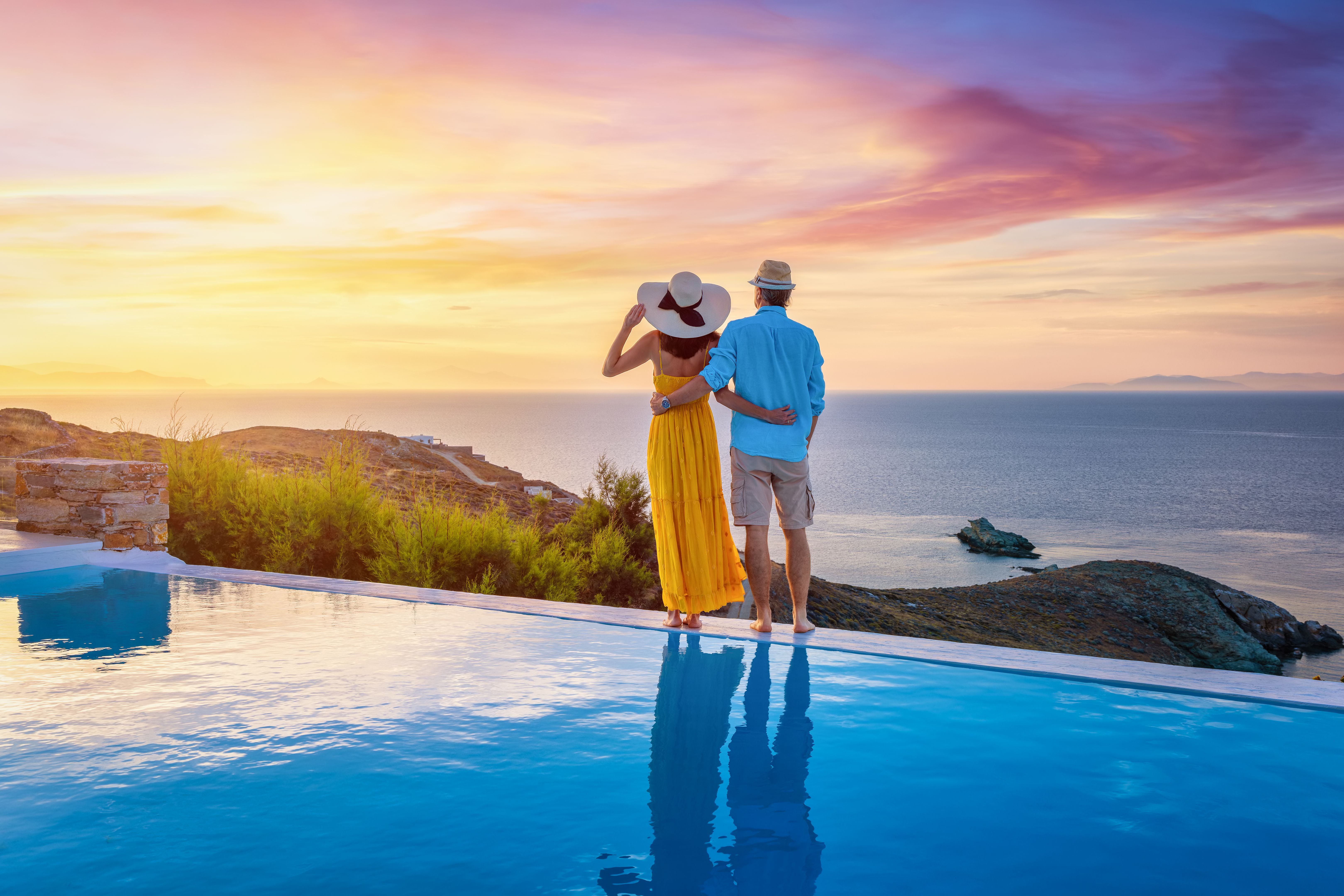 Luxury Travel - A  romantic couple  enjoys the beautiful sunset behind the mediterranean sea