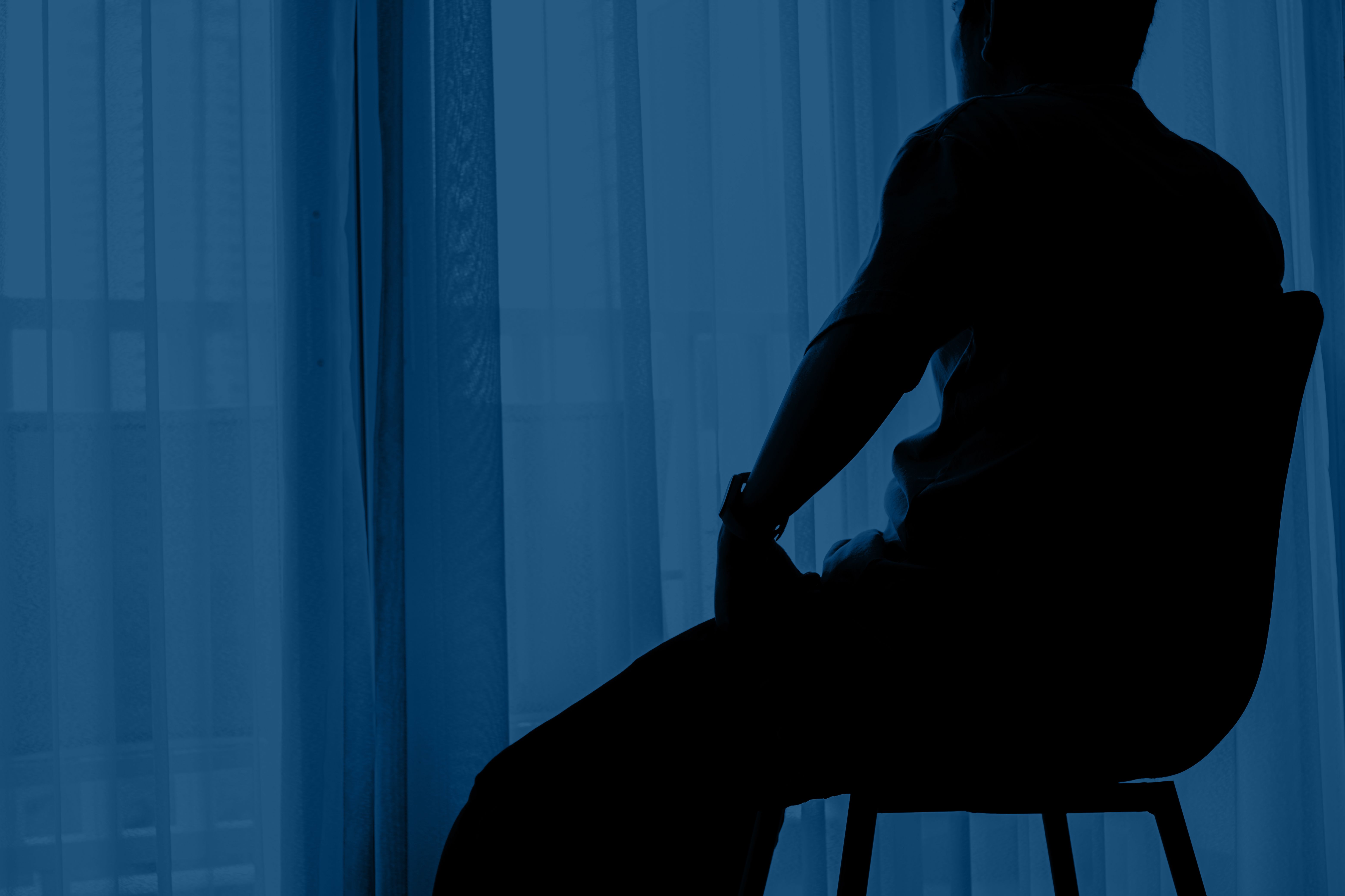 Man sitting alone in a dark room and ponder about something Man sitting alone in a dark room and ponder about something