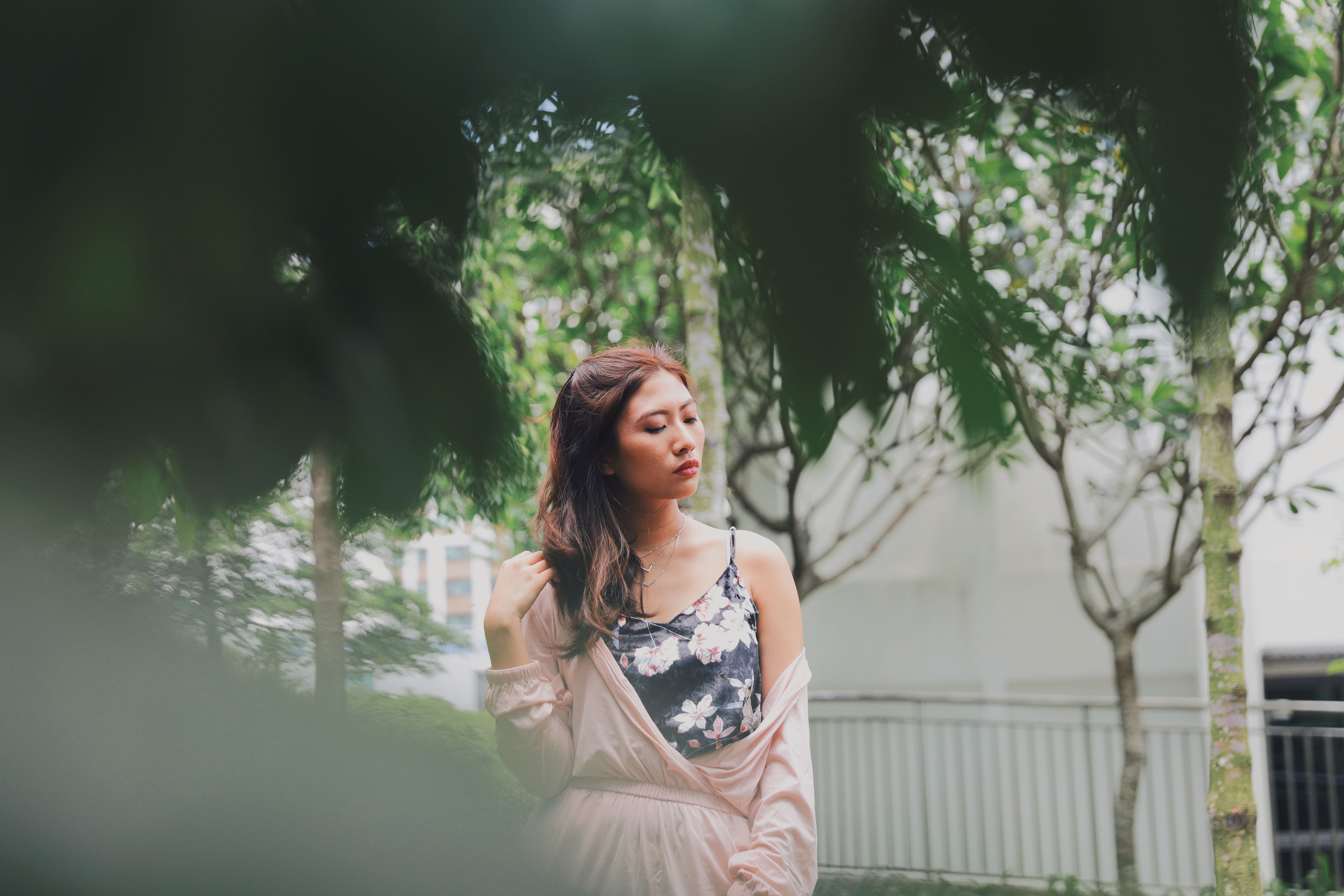 Young Woman Looking Away While Standing Against Trees