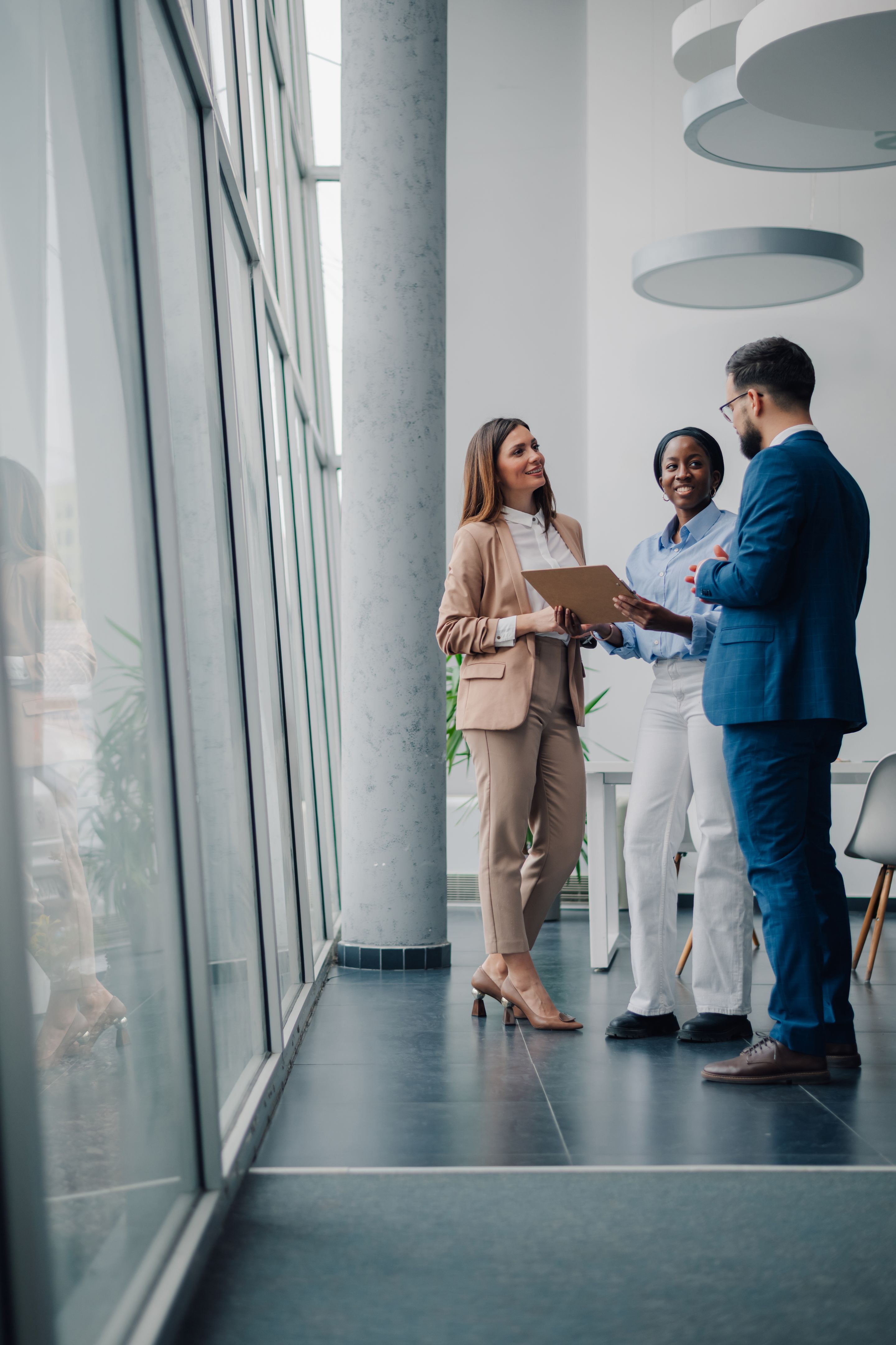 Business team discussing work in modern office building hallway