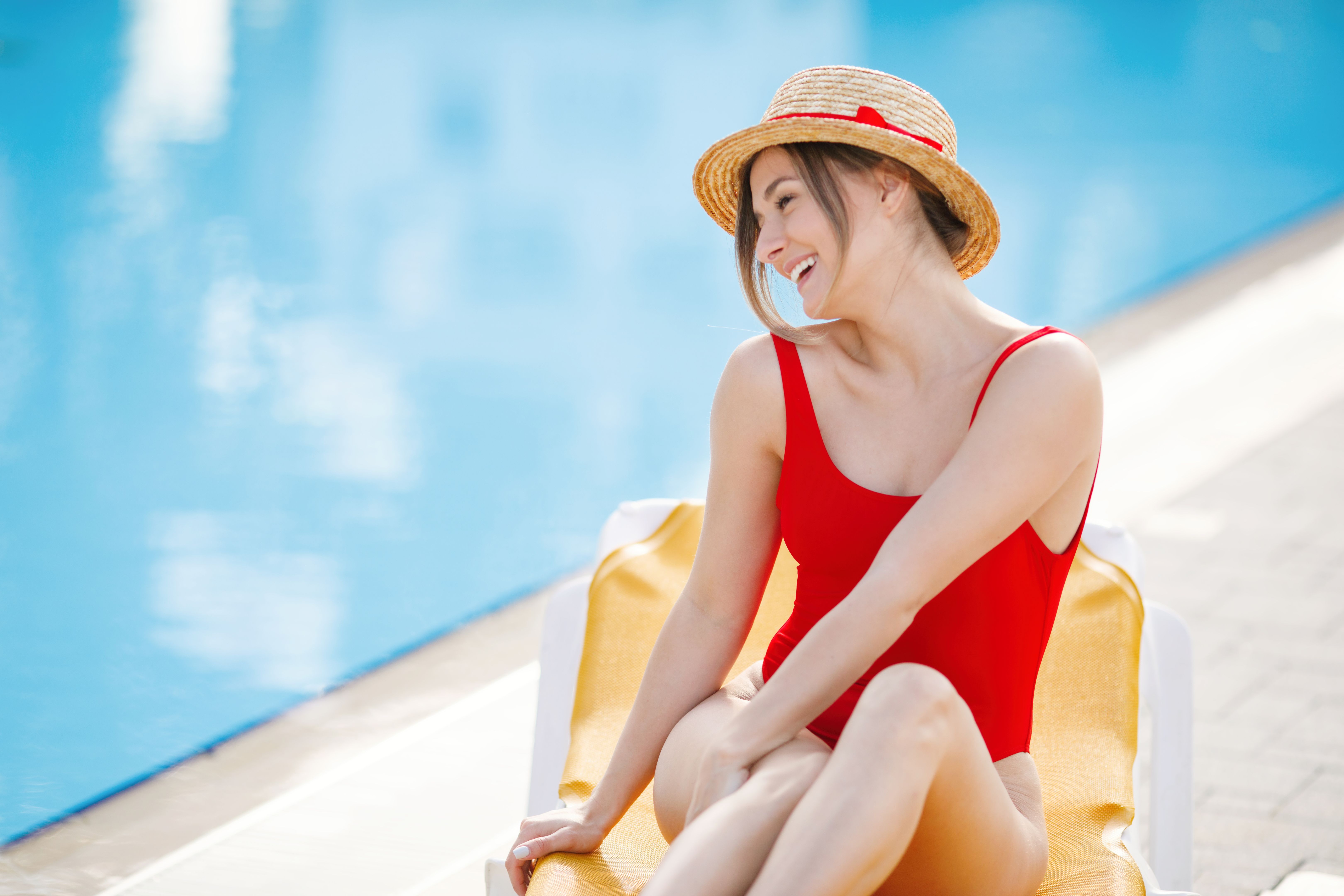 Enjoying suntan and vacation. Beautiful girl relaxing near the swimming pool
