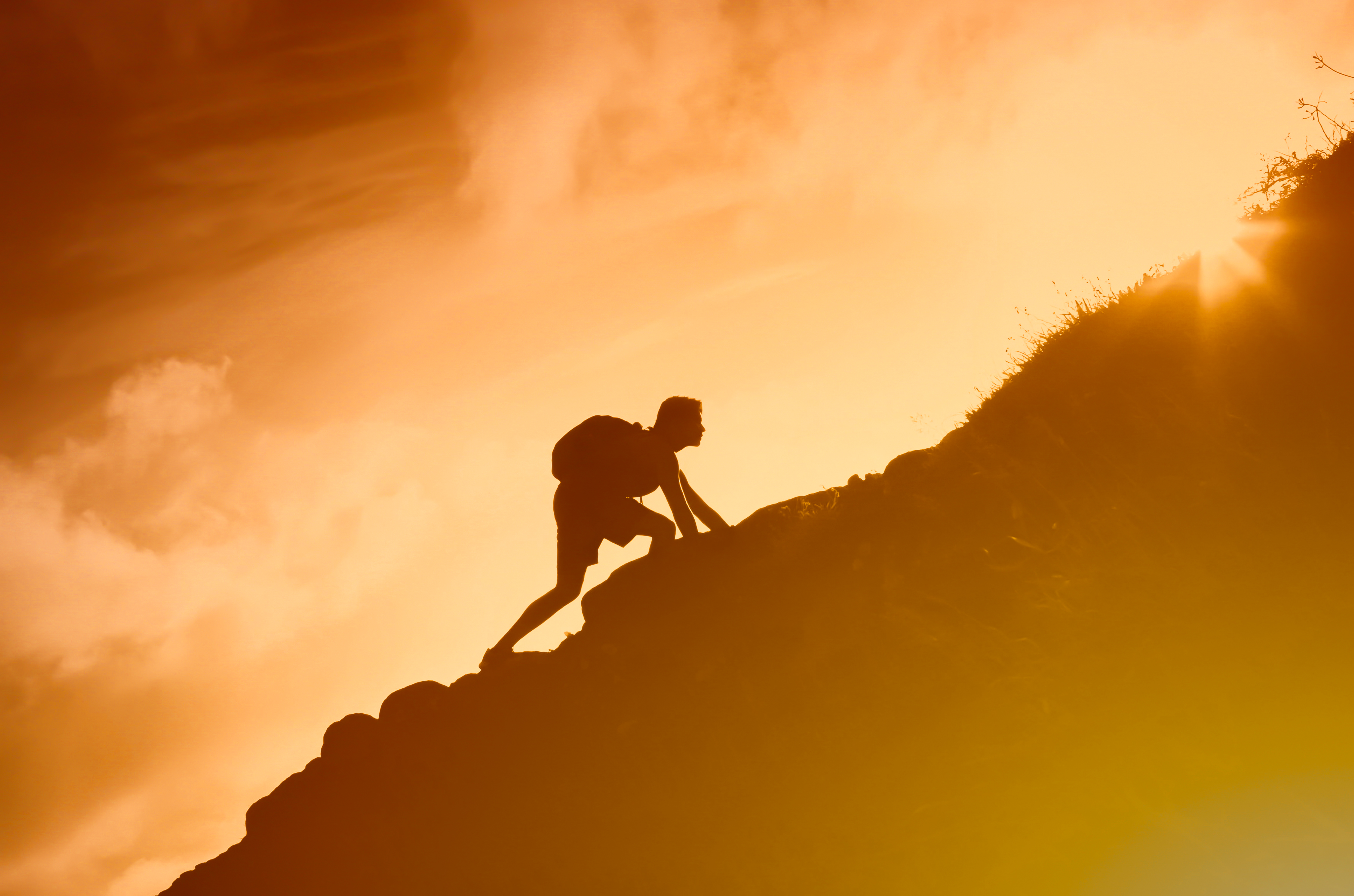 Man climbing up mountain cliff. Working hard to reach goals Man climbing up mountain cliff. Working hard to reach goals