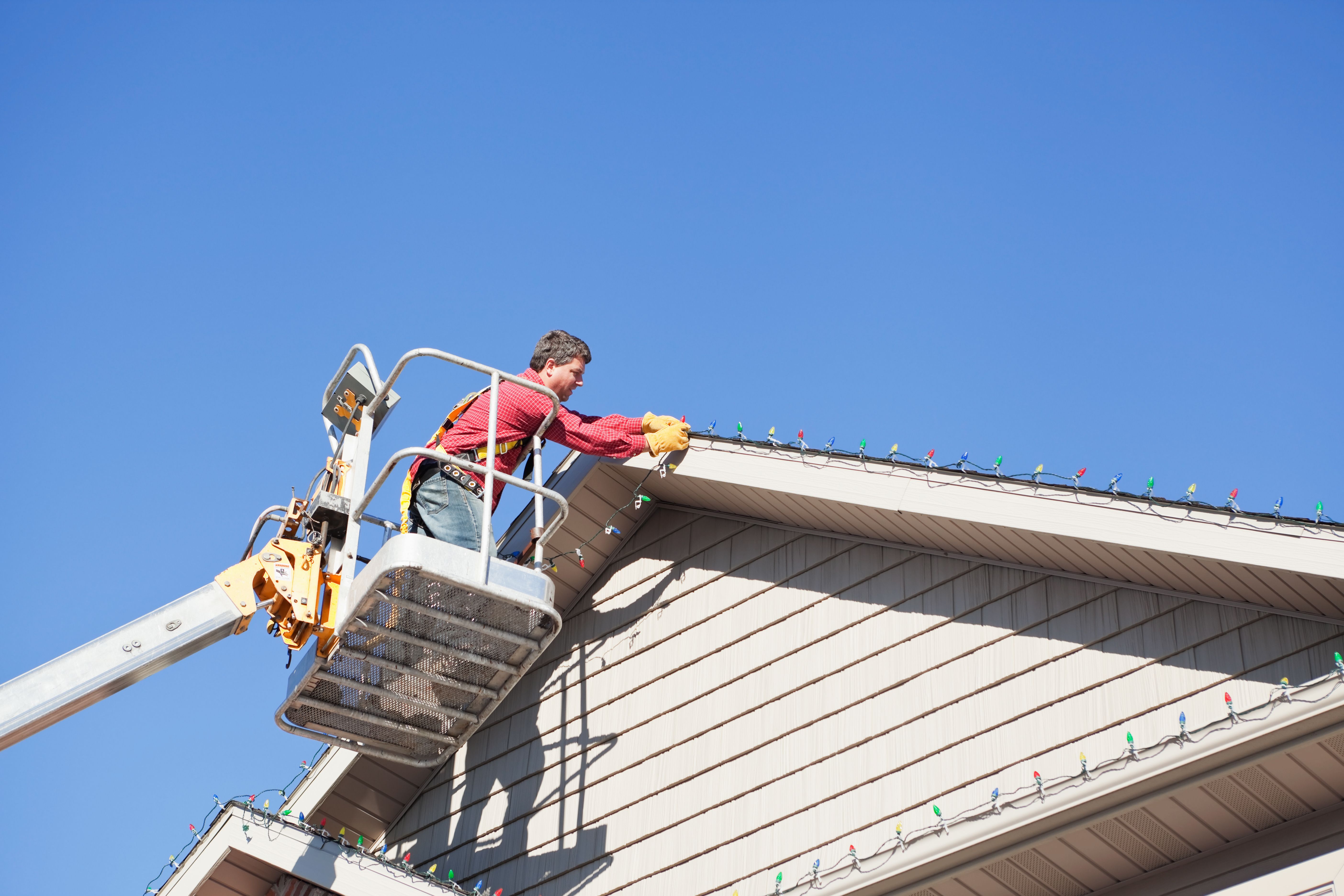 Professional Installing LED Christmas Lights on House Roof Professional Installing LED Christmas Lights on House Roof