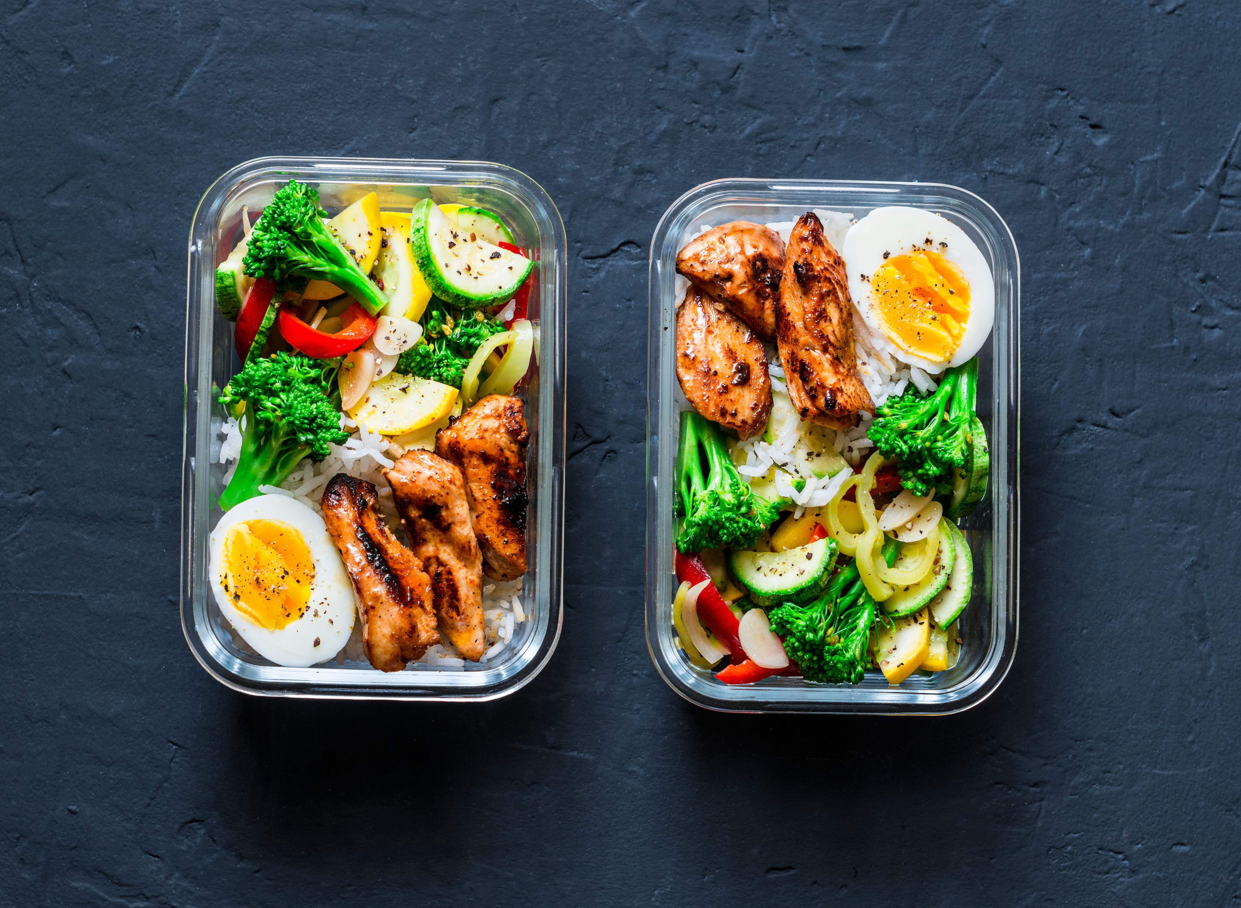 Rice, stewed vegetables, egg, teriyaki chicken - healthy balanced lunch box on a dark background, top view. Home food for office concept Rice, stewed vegetables, egg, teriyaki chicken - healthy balanced lunch box on a dark background, top view. Home food for office concept