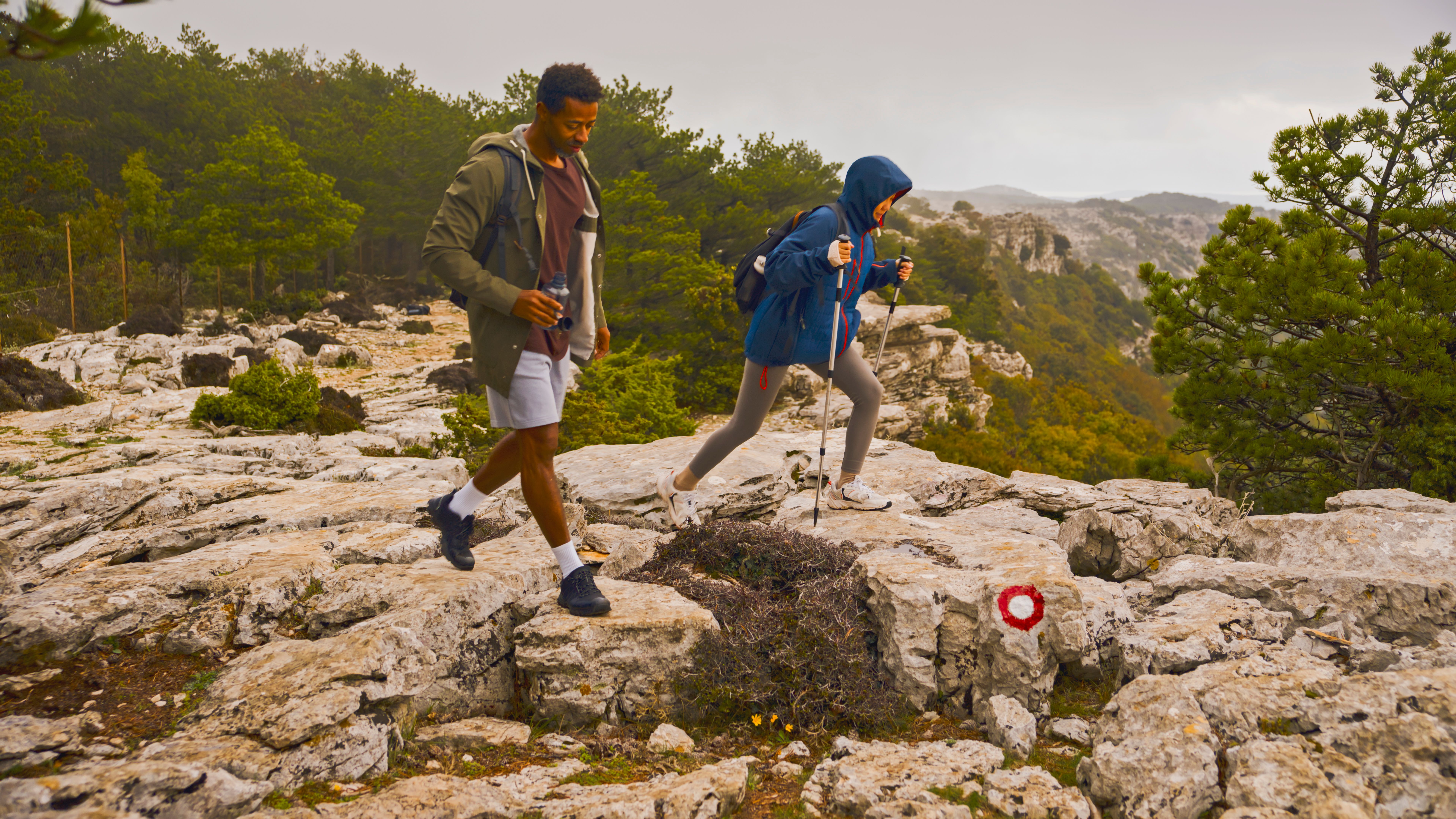 Mid-Adult Couple Navigating Rocky Mountain Trail During Overcast Day
