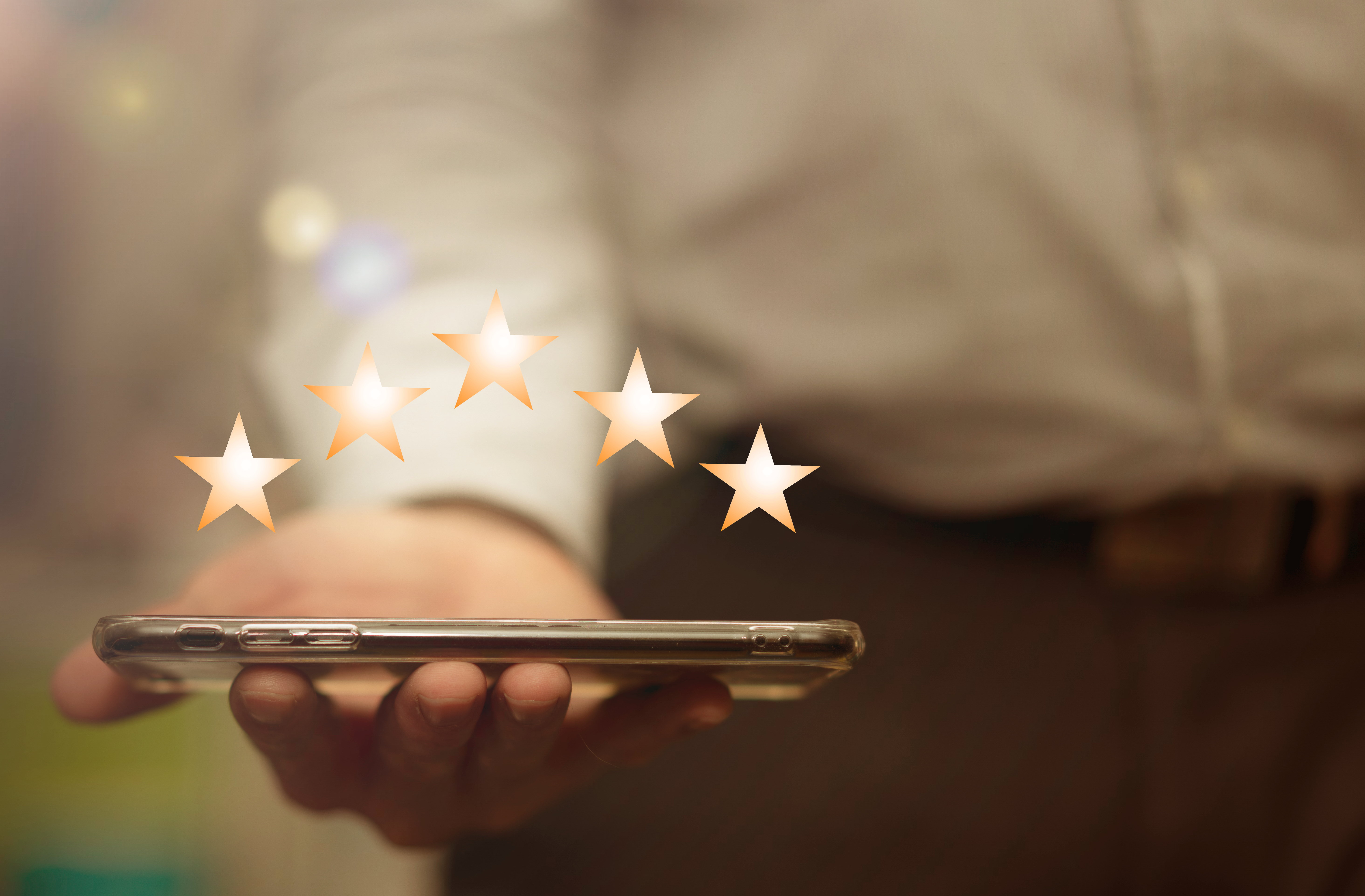 Businessman offering cell phone to show five stars social reviews Businessman offering cell phone to show five stars social reviews