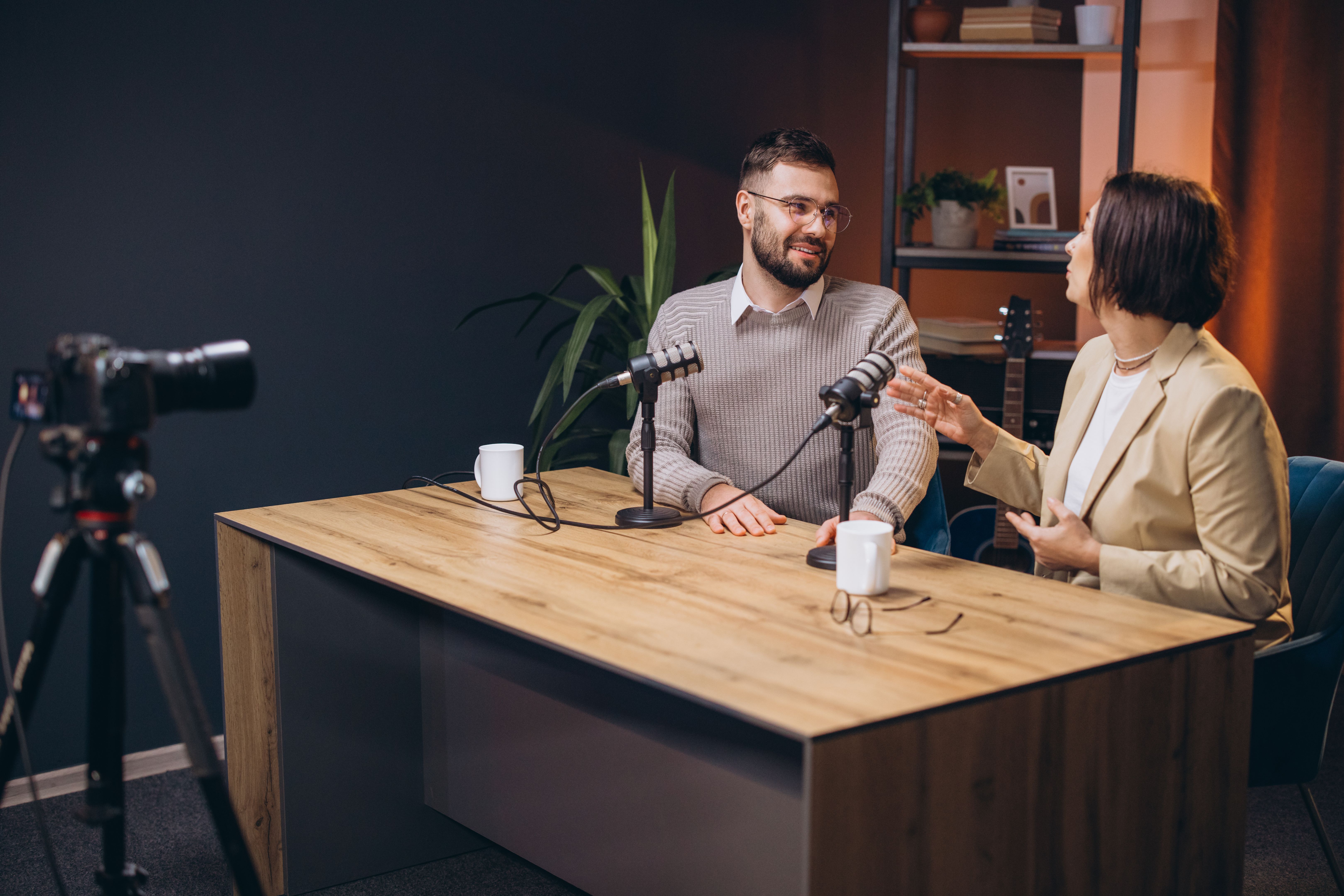 Two content creators recording a podcast episode in a professional studio, discussing and sharing their expertise