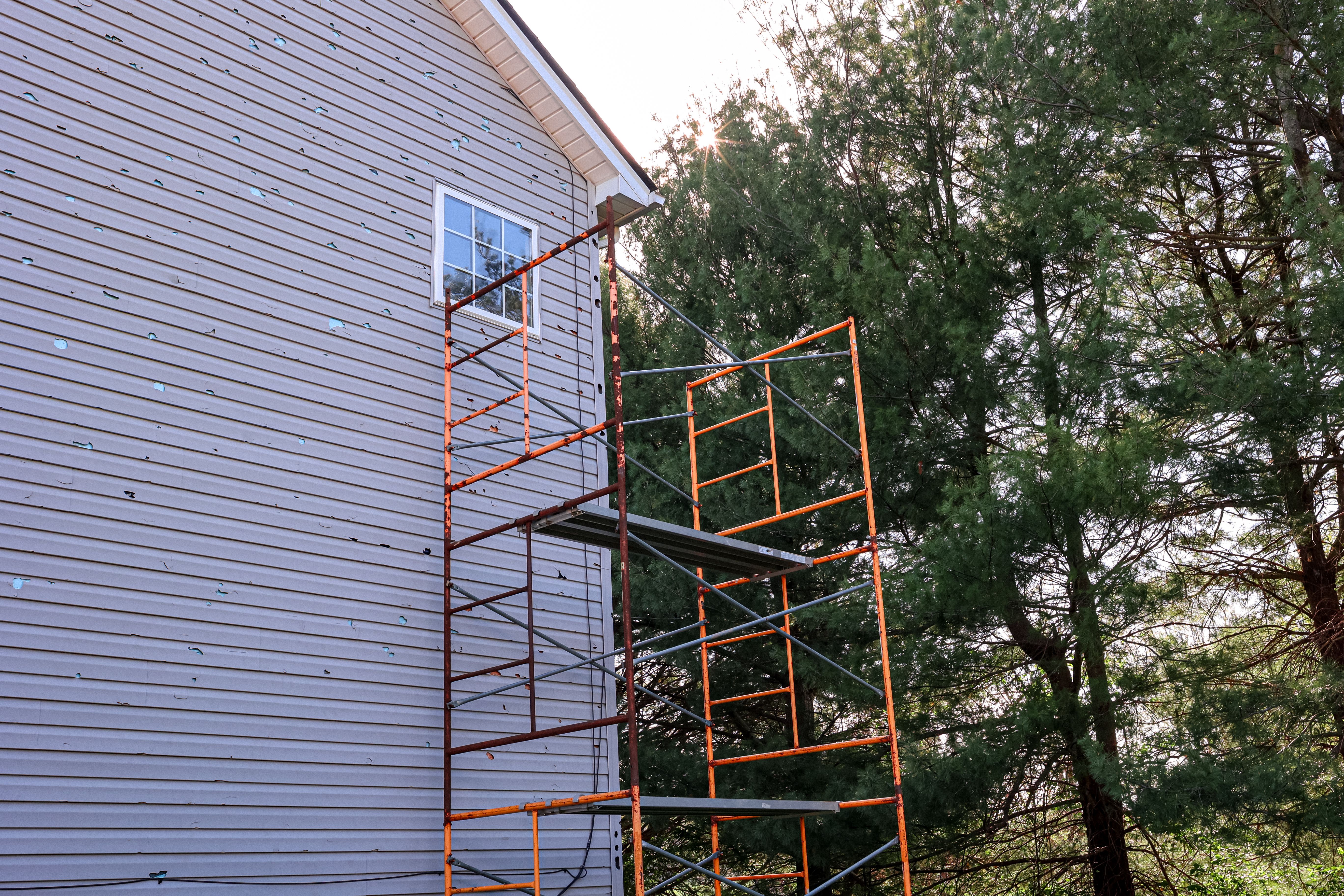 Scaffold On The Side of A House To Repair Vinyl Siding