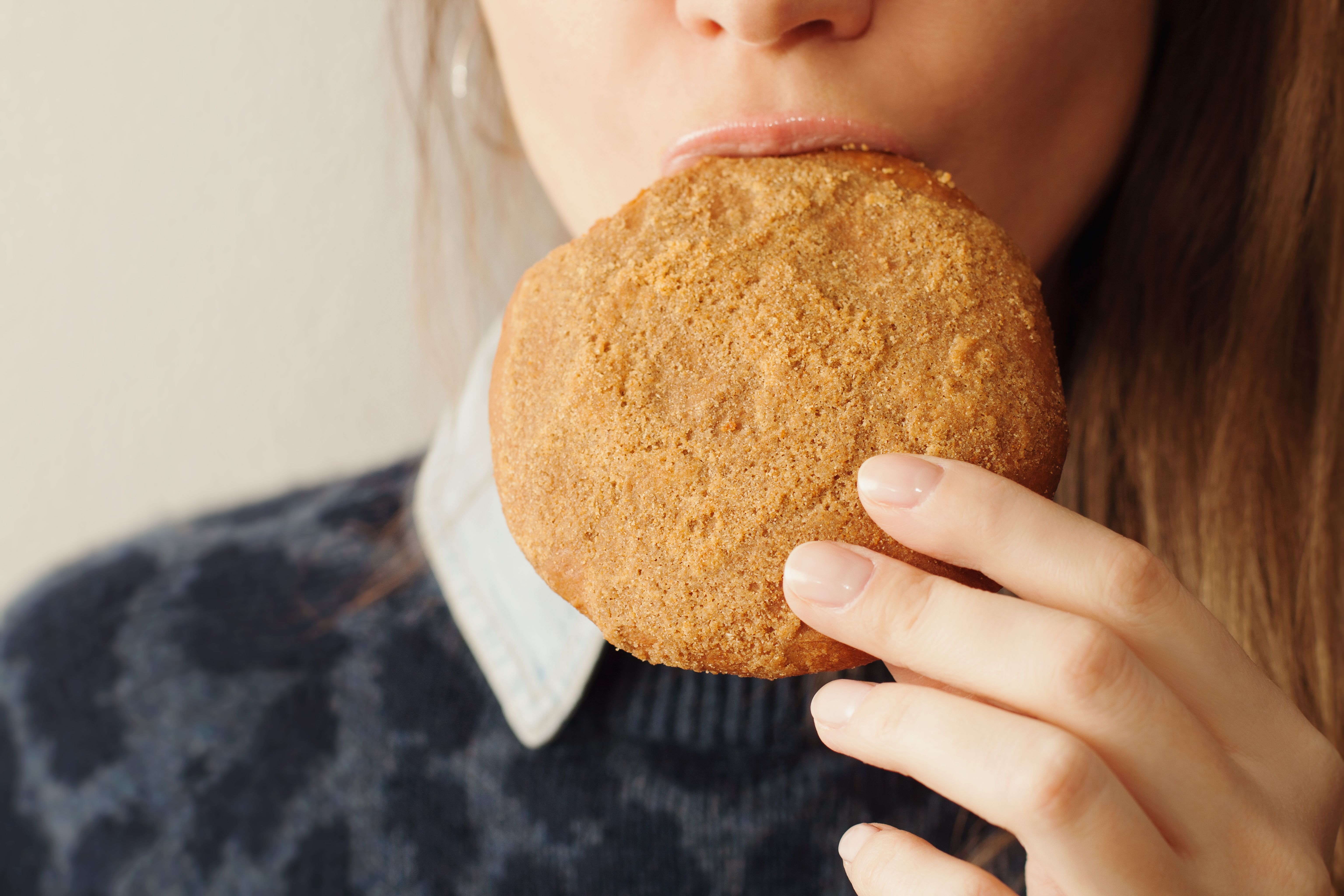 Portrait of young woman eating home made  cookie with oatmeal.