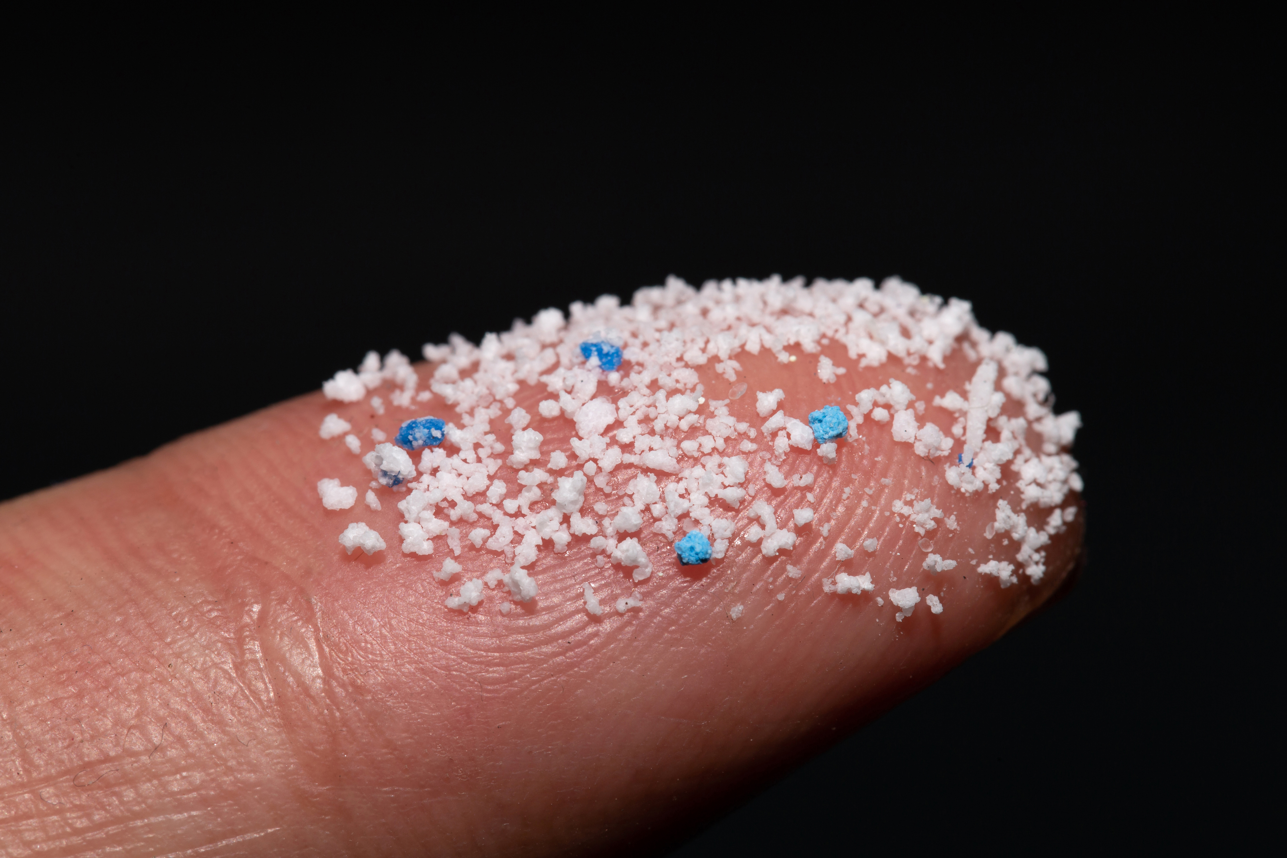 Small Plastic pellets on the finger.Micro plastic.air pollution Small Plastic pellets on the finger.Micro plastic.air pollution