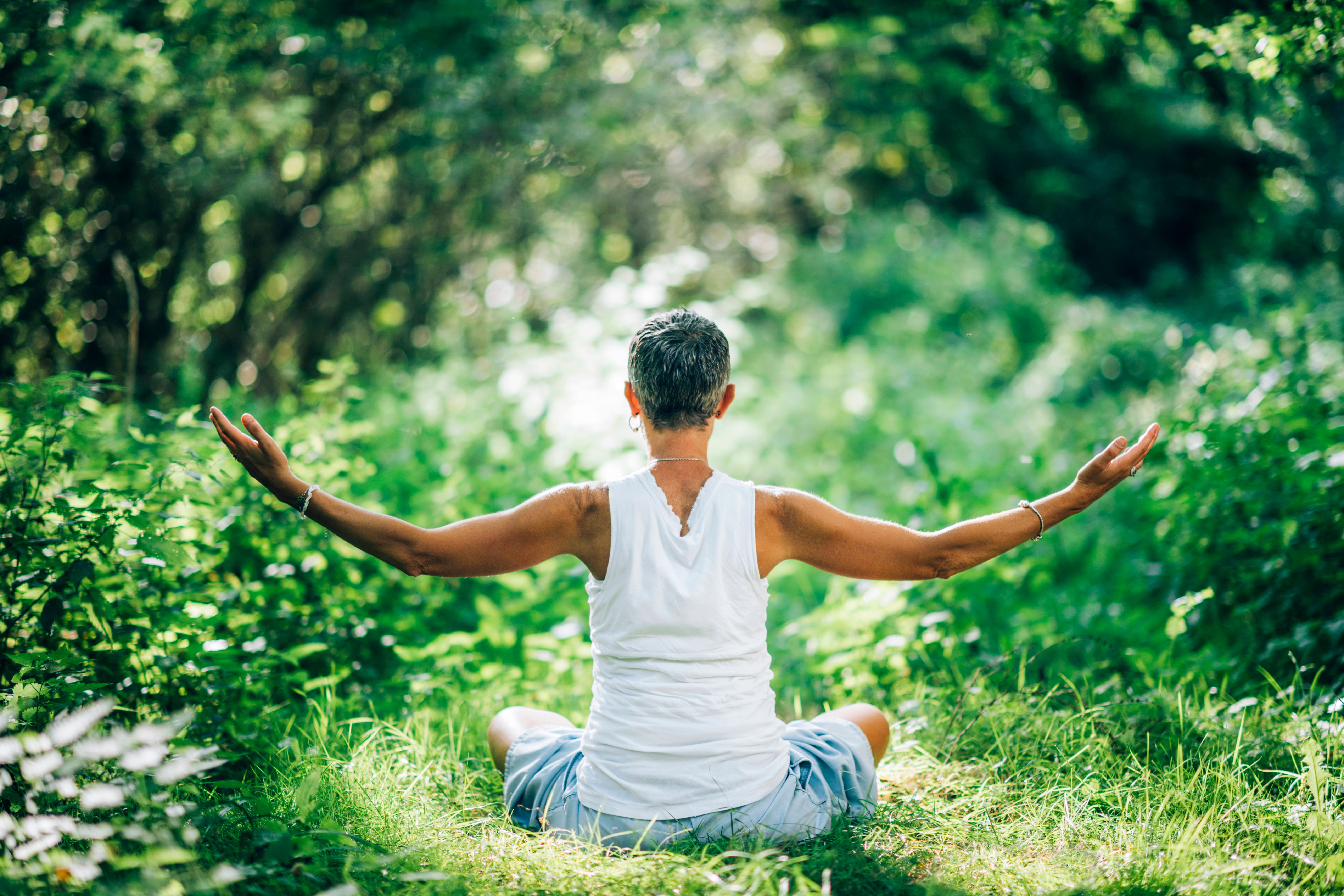 Inner Peace Meditation. Mindful Woman Meditating With Open Arms, Sitting On The Ground