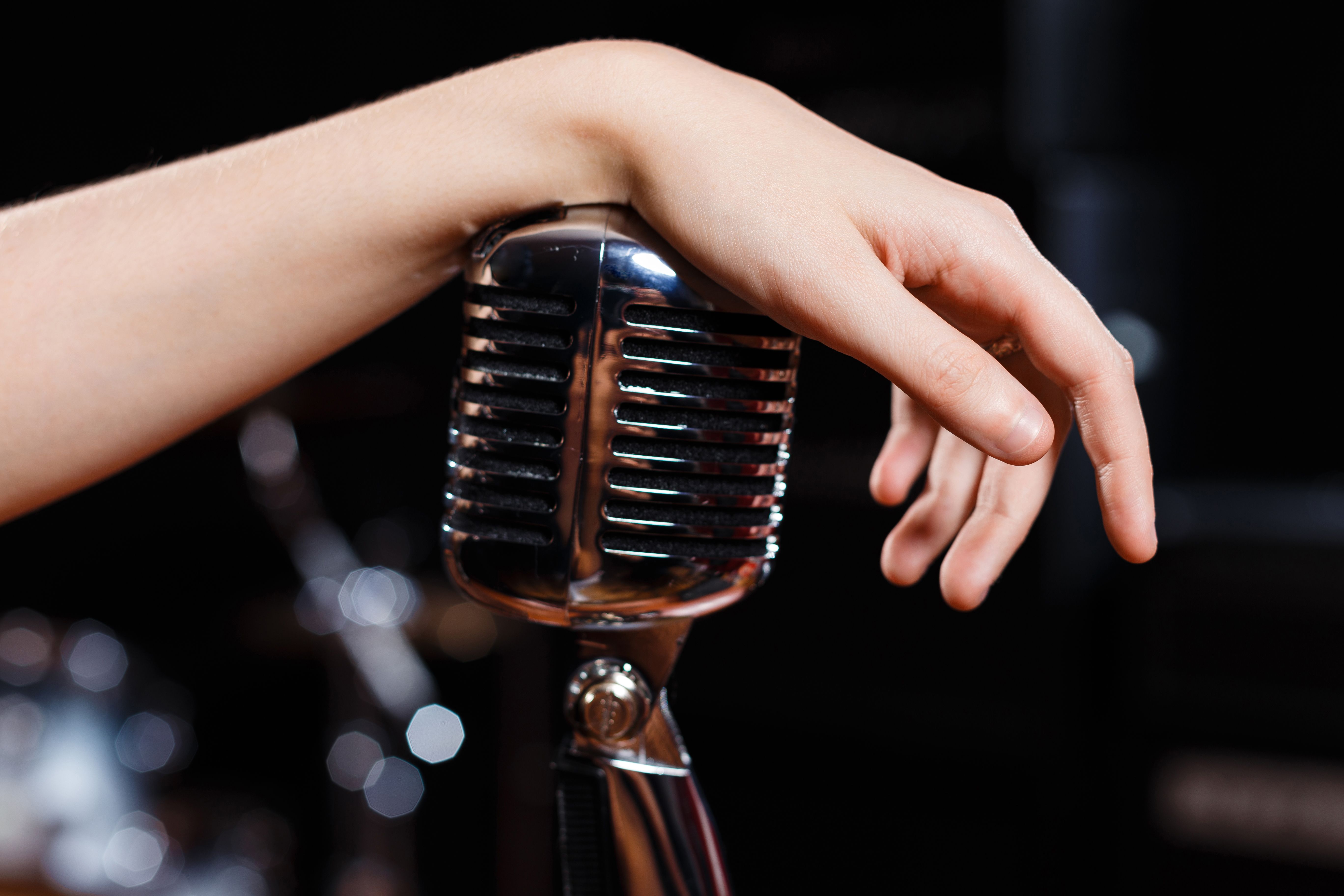 Female hand on retro microphone close-up