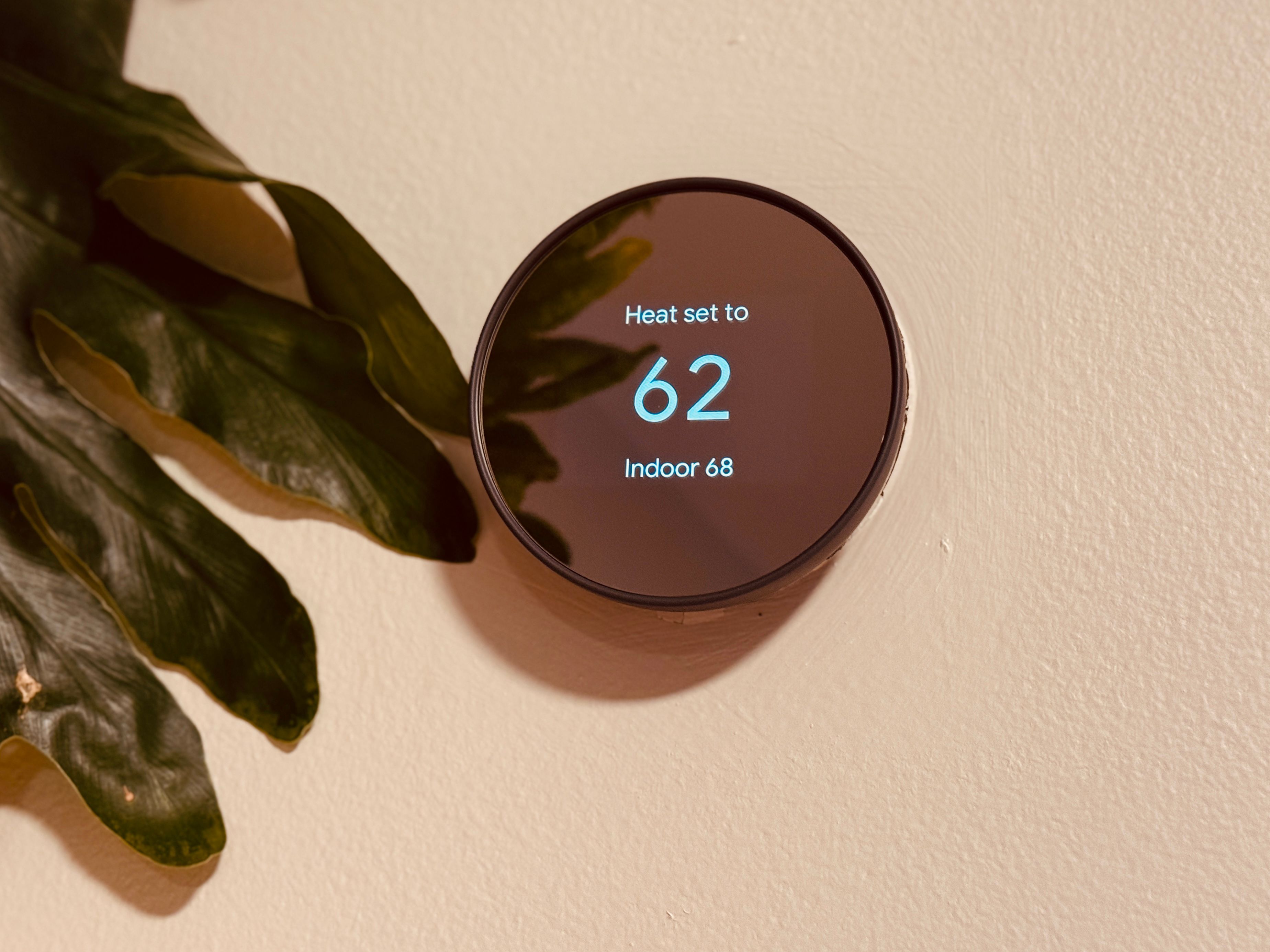 Smart thermostat mounted on a wall, helping reduce energy consumption by automatically adjusting home temperature for eco-friendly efficiency.