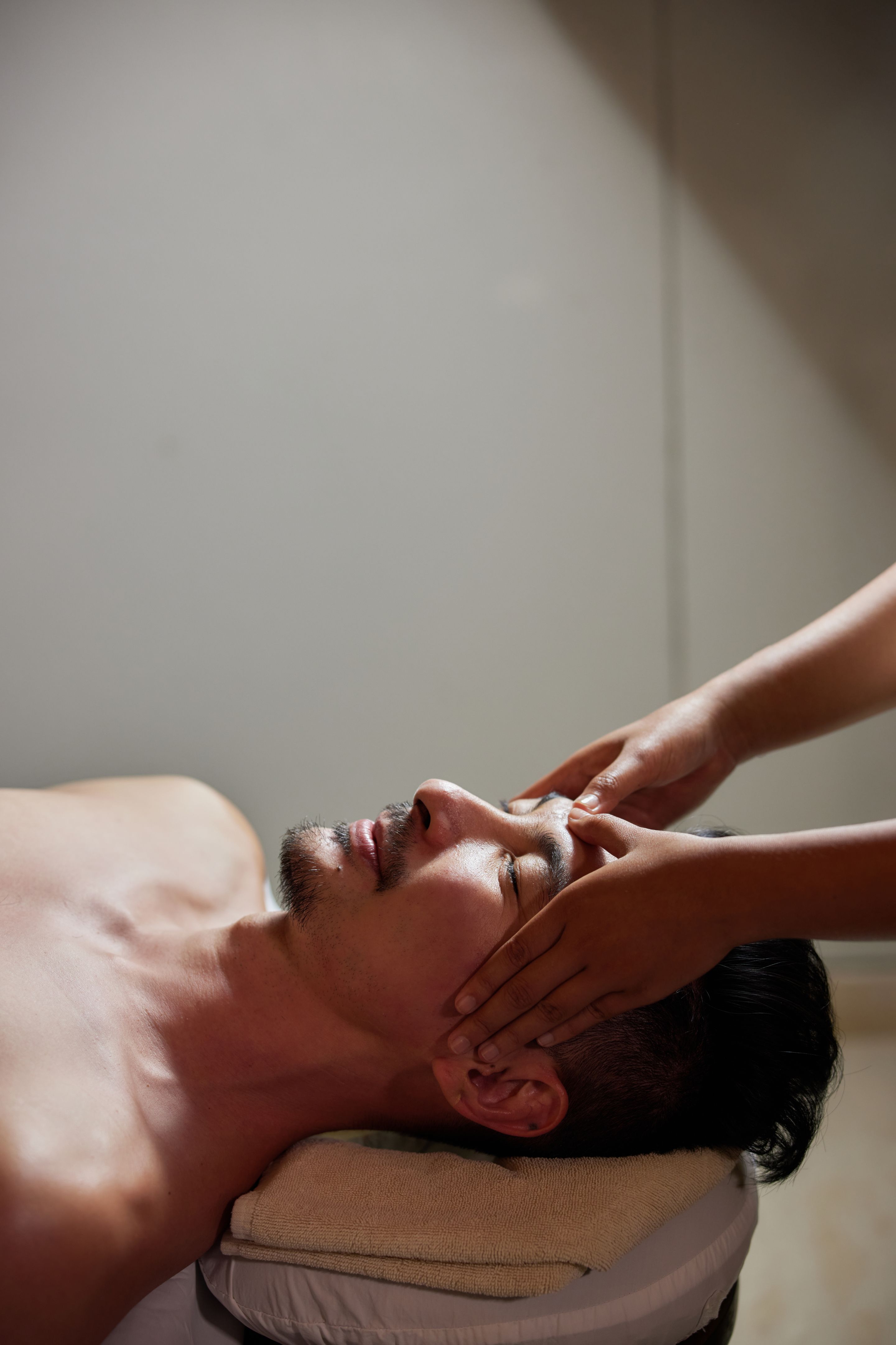 Face massage. Close-up of young man getting spa massage treatment at beauty spa salon. Spa skin and body care. Facial beauty treatment. Cosmetology.