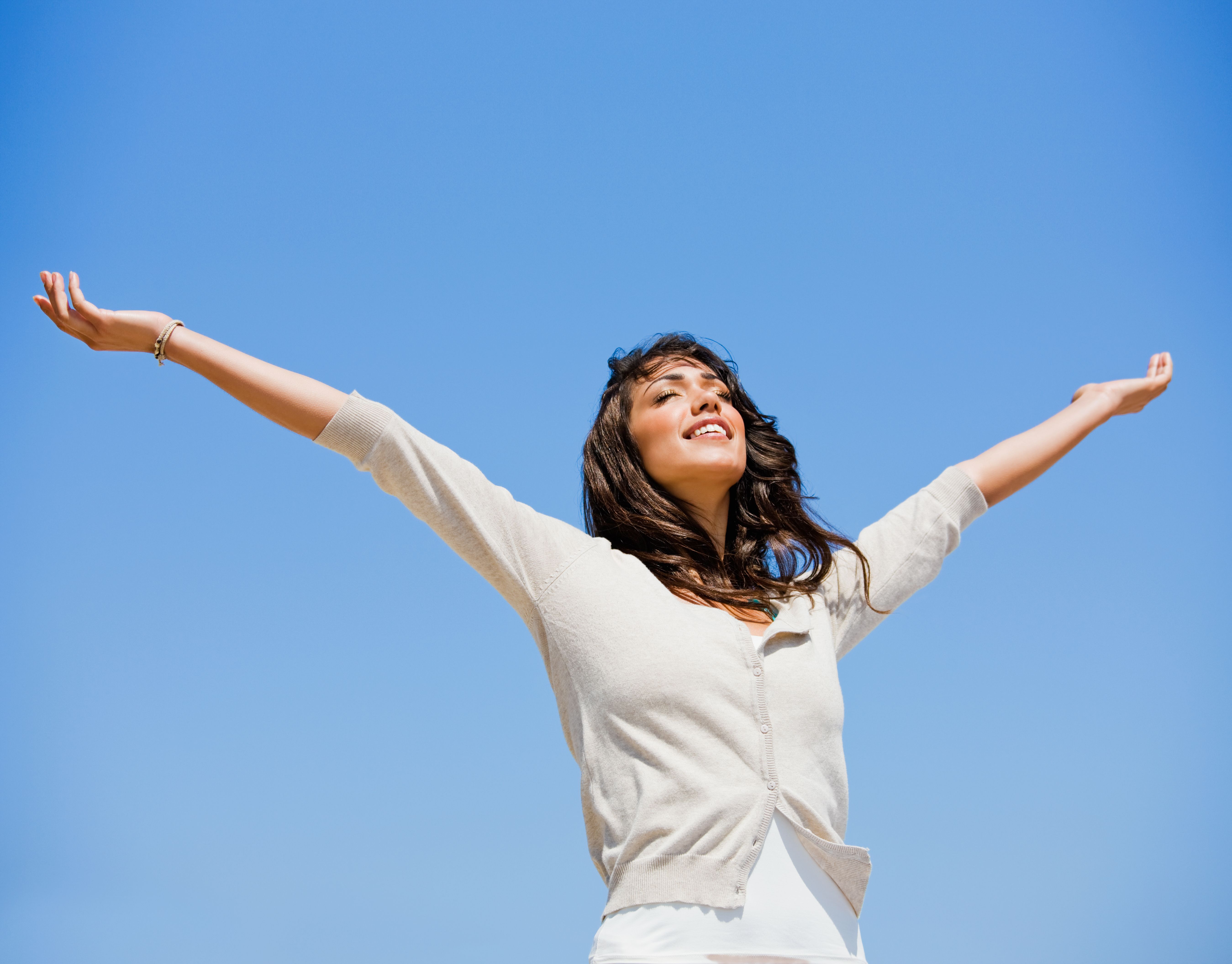 Beautiful young woman with arms raised