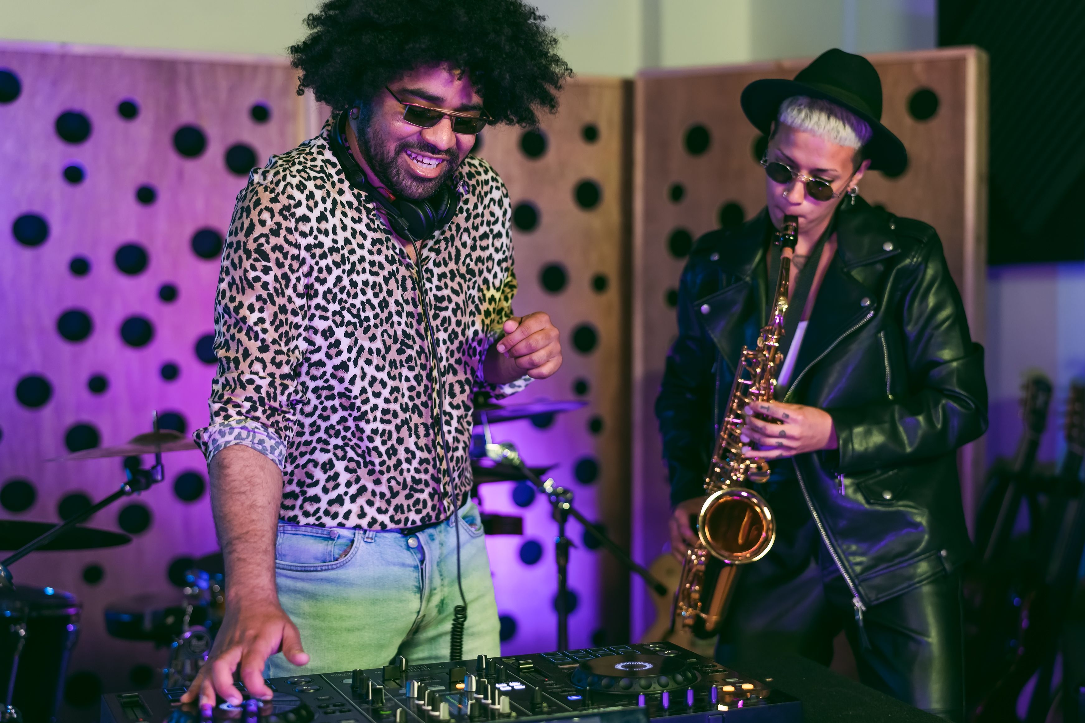 Young happy people playing music with dj mixer and saxophone in house studio - Youth musician entertainment concept