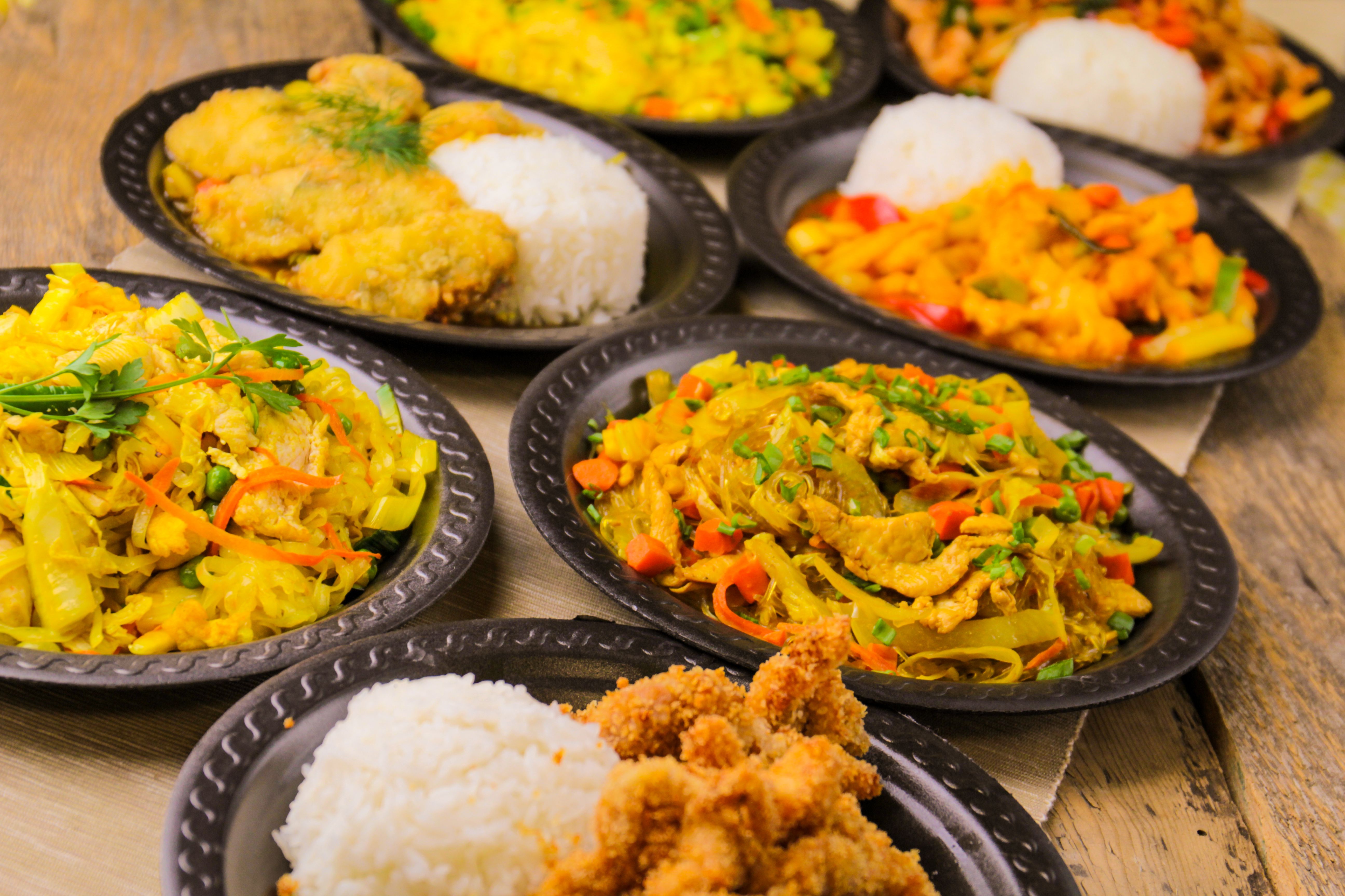 Plates with delicious oriental food on an old wooden table Plates with delicious oriental food on an old wooden table