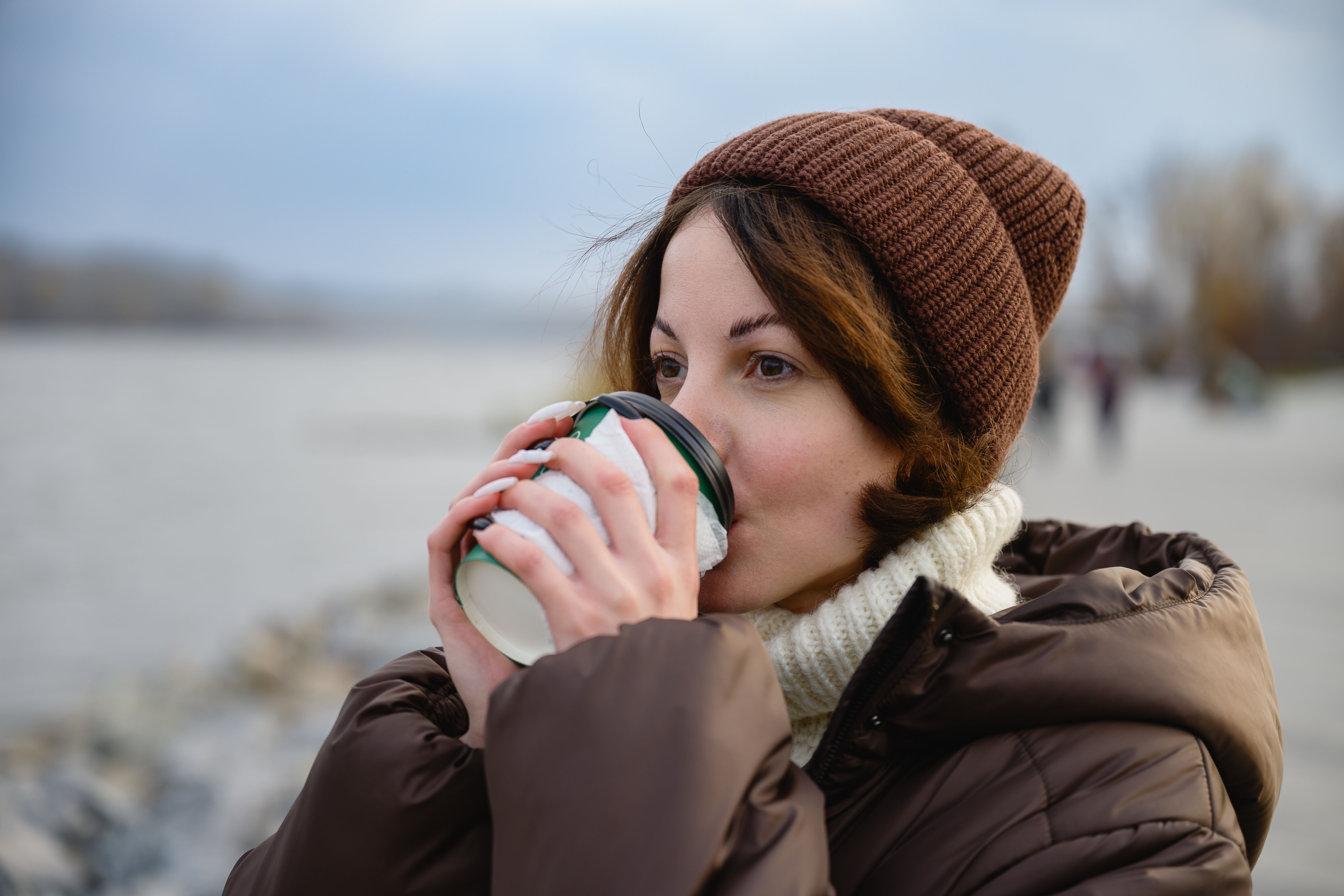 relaxed Woman drinking hot coffee outdoors in winter