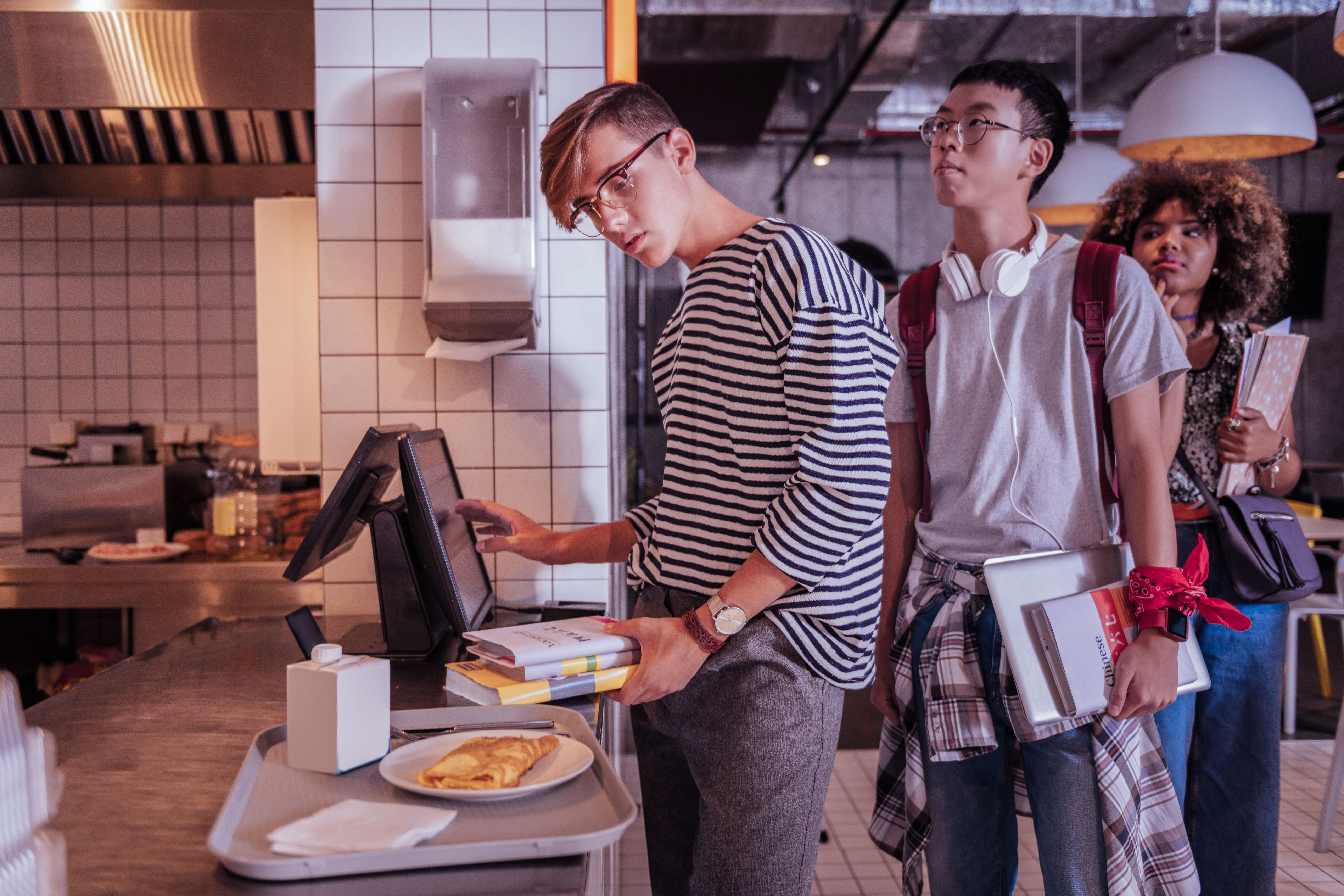 Attentive boy doing payment for his dinner