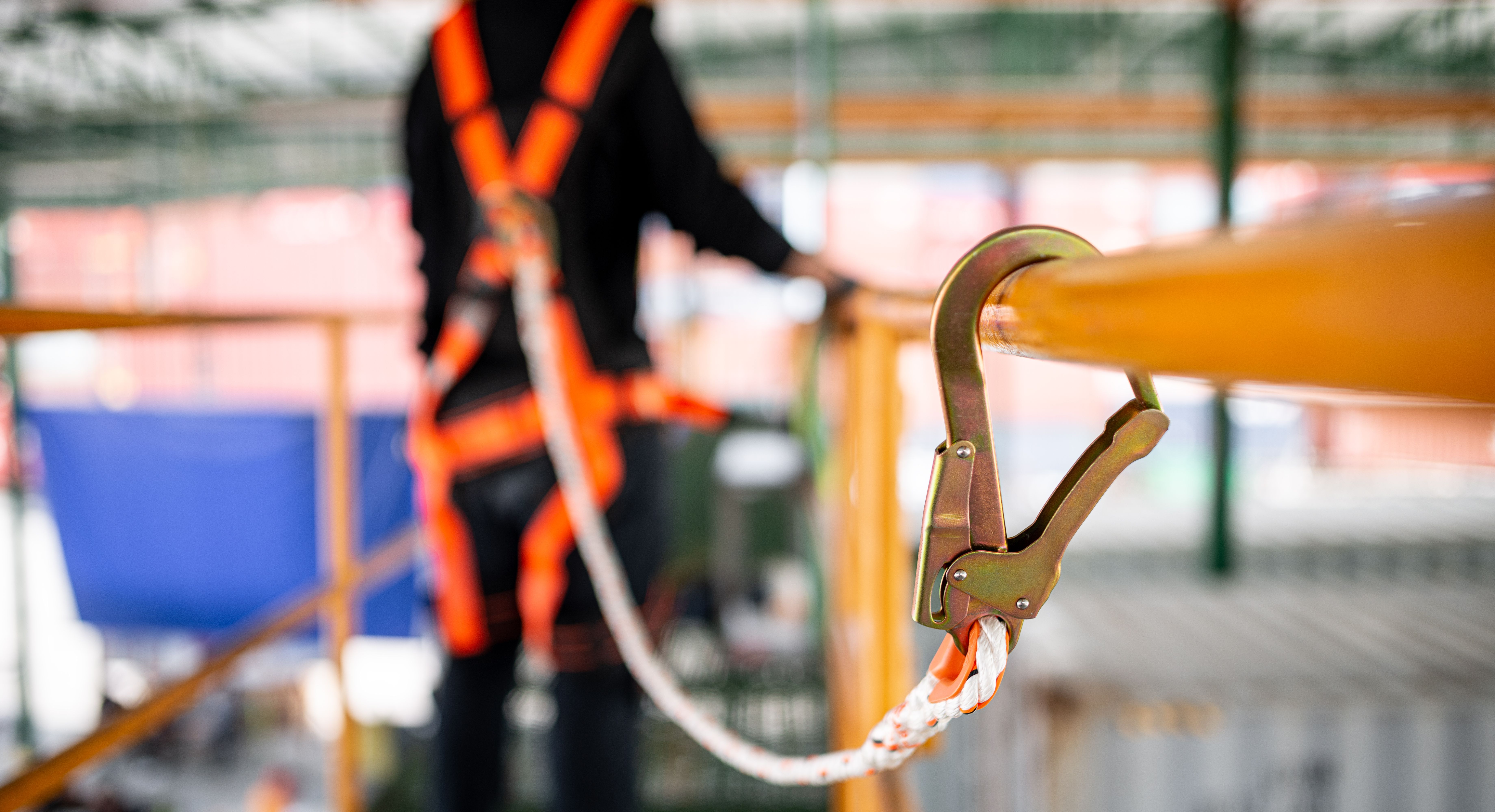 Construction worker wearing safety harness working at high place