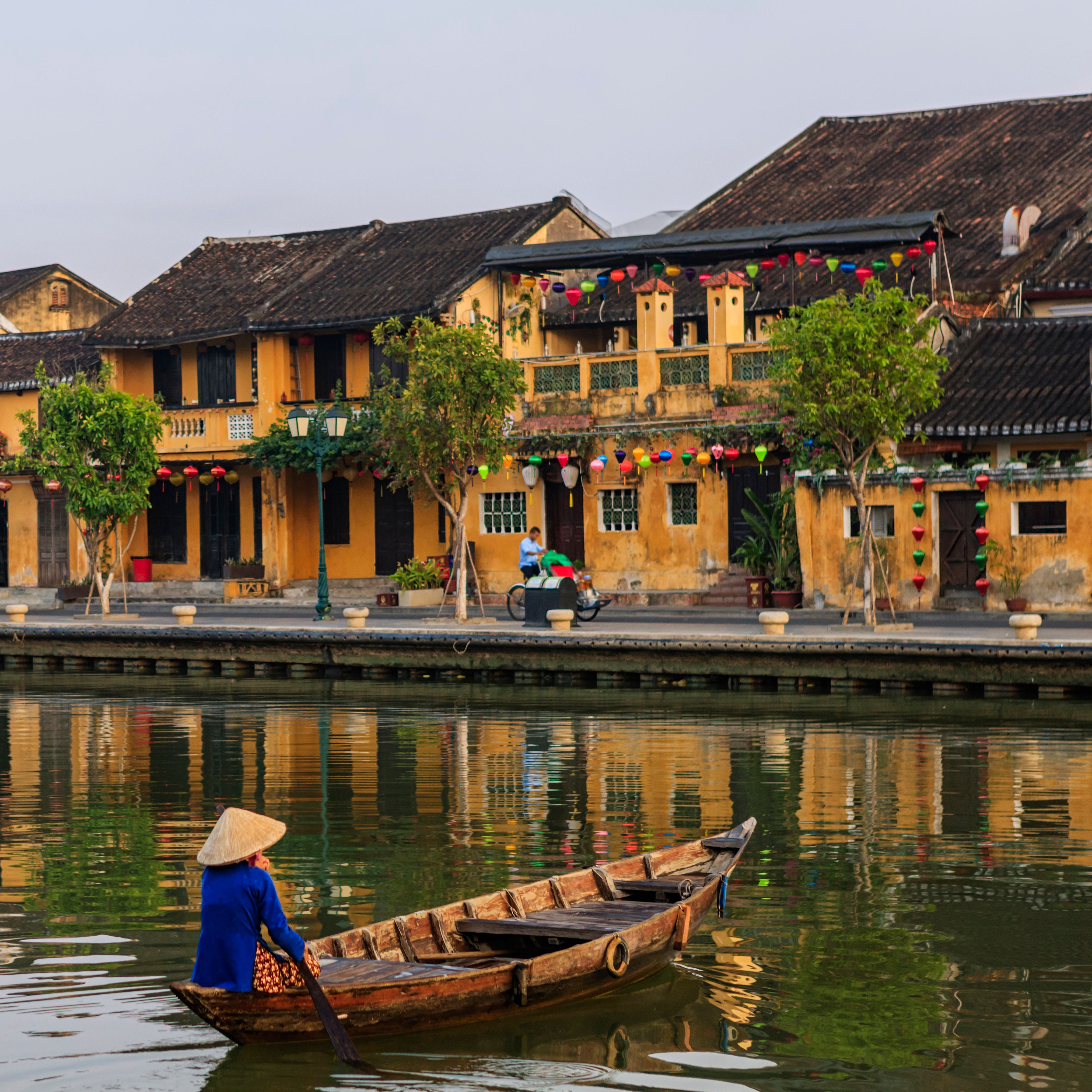 Vietnamese woman paddling in old town in Hoi An city, Vietnam Vietnamese woman paddling in old town in Hoi An city, Vietnam