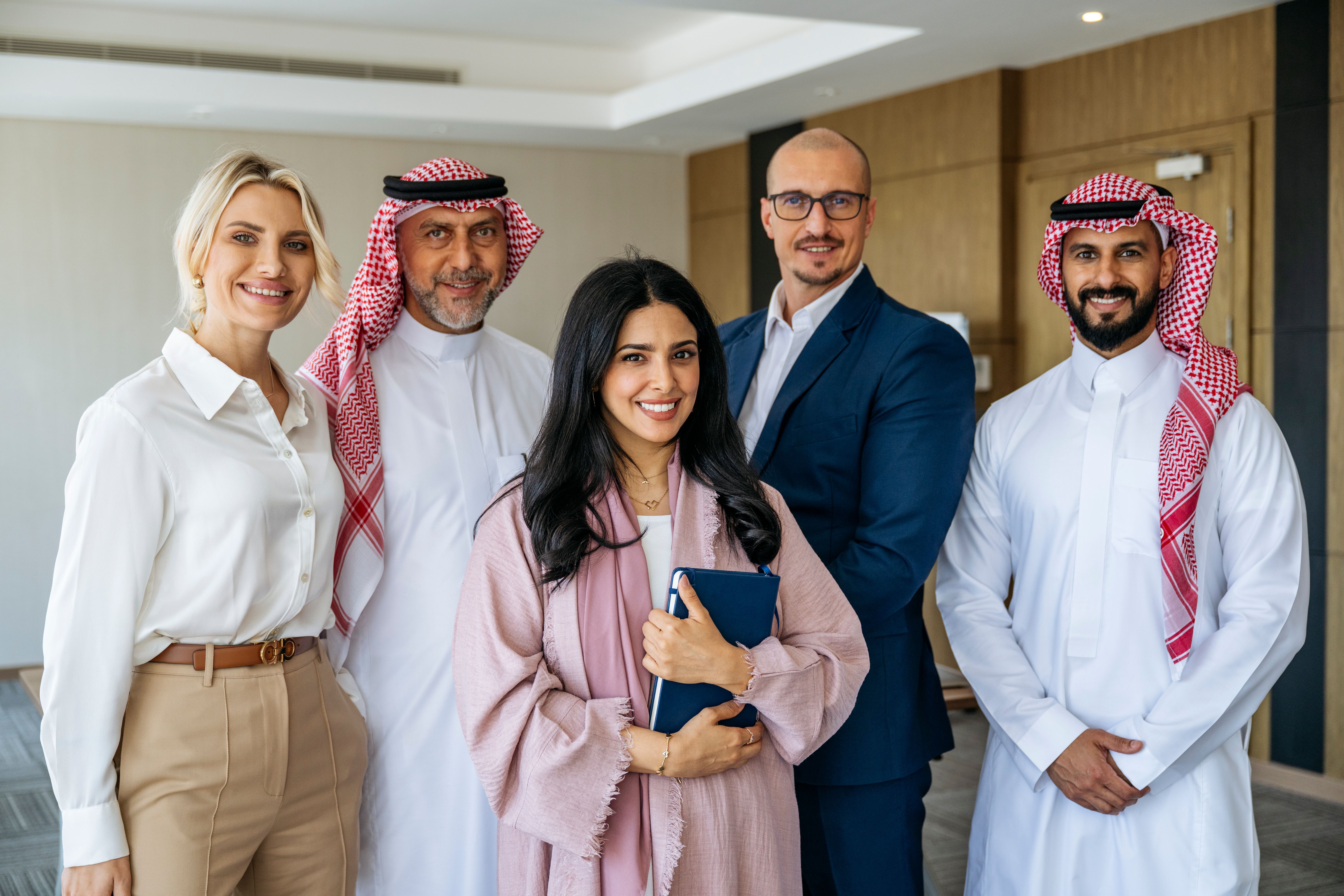 Portrait of five multi racial business partners in Middle East office smiling towards camera