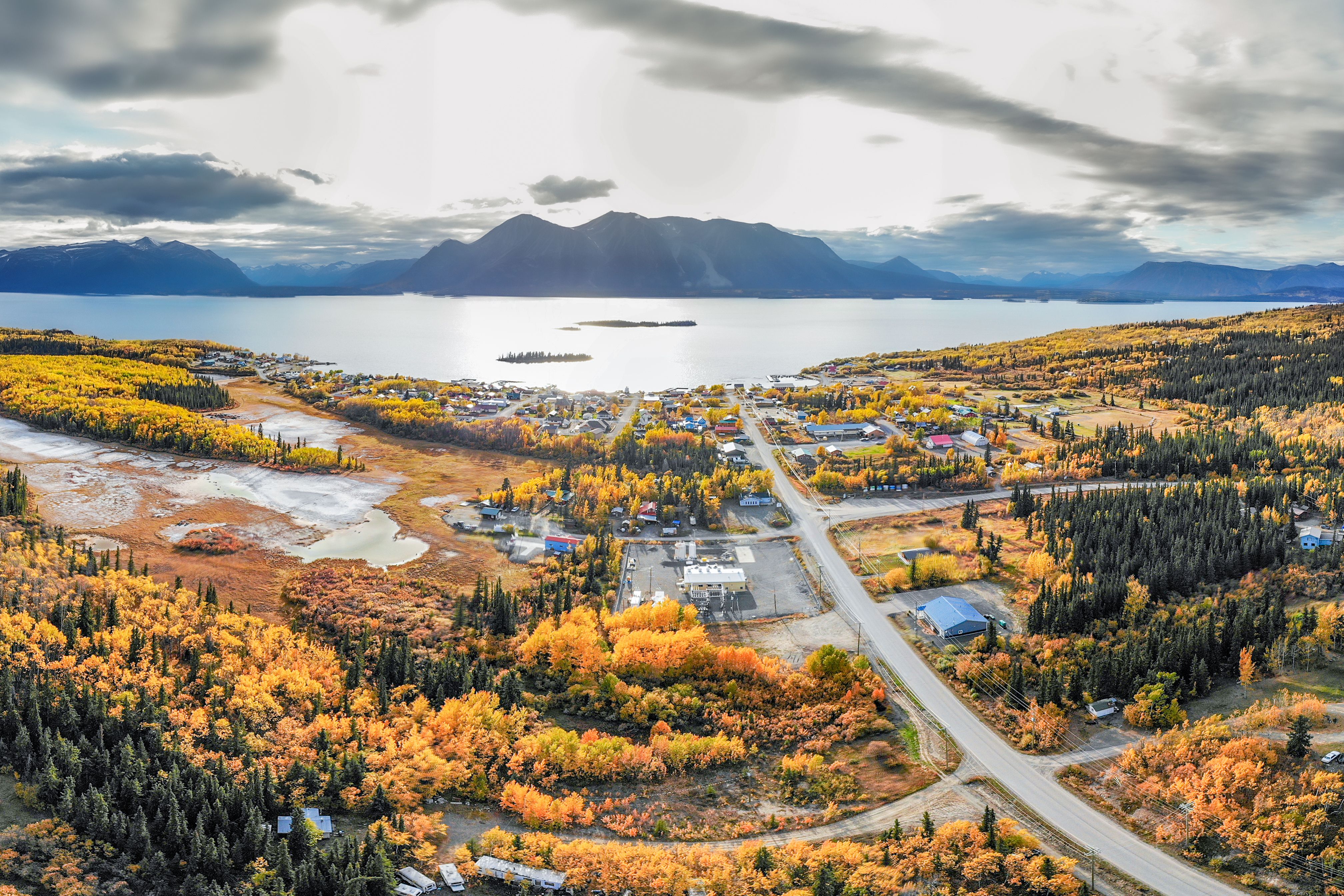 The small northern British Columbian town of Atlin near the Yukon Territory border. Taken by drone aerial shot in September during the peak fall autumn colors with yellow bright trees.