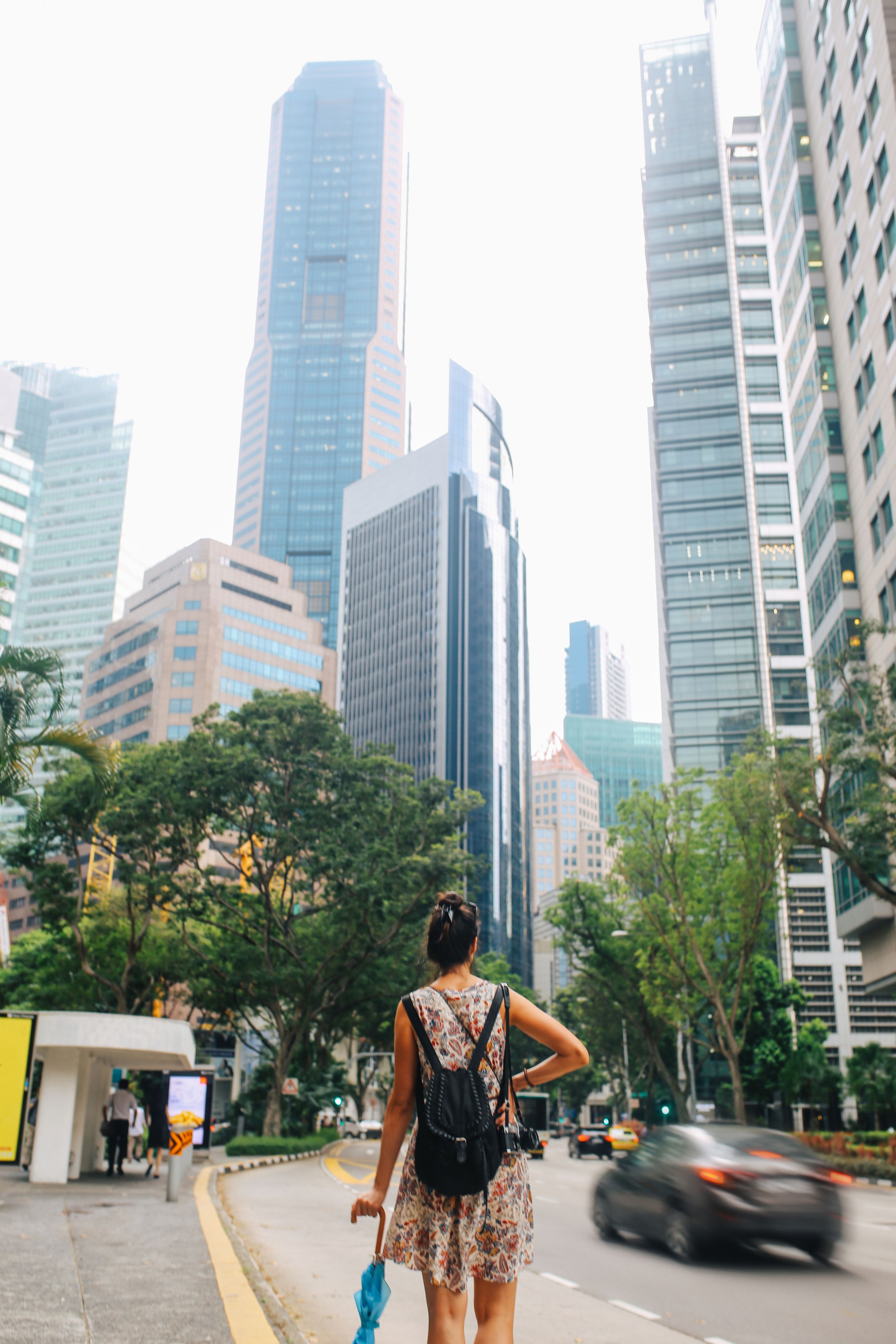 Young fashionable solo traveler woman walking in Singapore downtown Young fashionable solo traveler woman walking in Singapore downtown