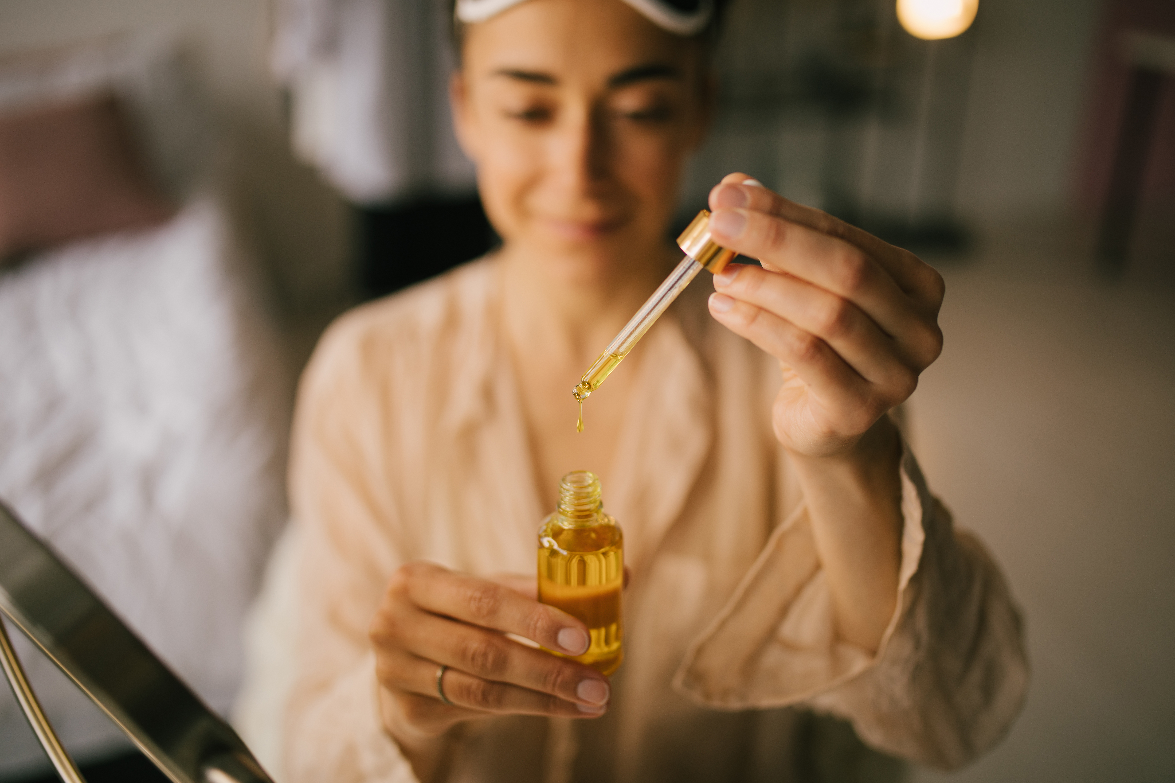Portrait of beautiful young woman holding face oil. Beauty cosmetic concept. Portrait of beautiful young woman holding face oil. Beauty cosmetic concept.