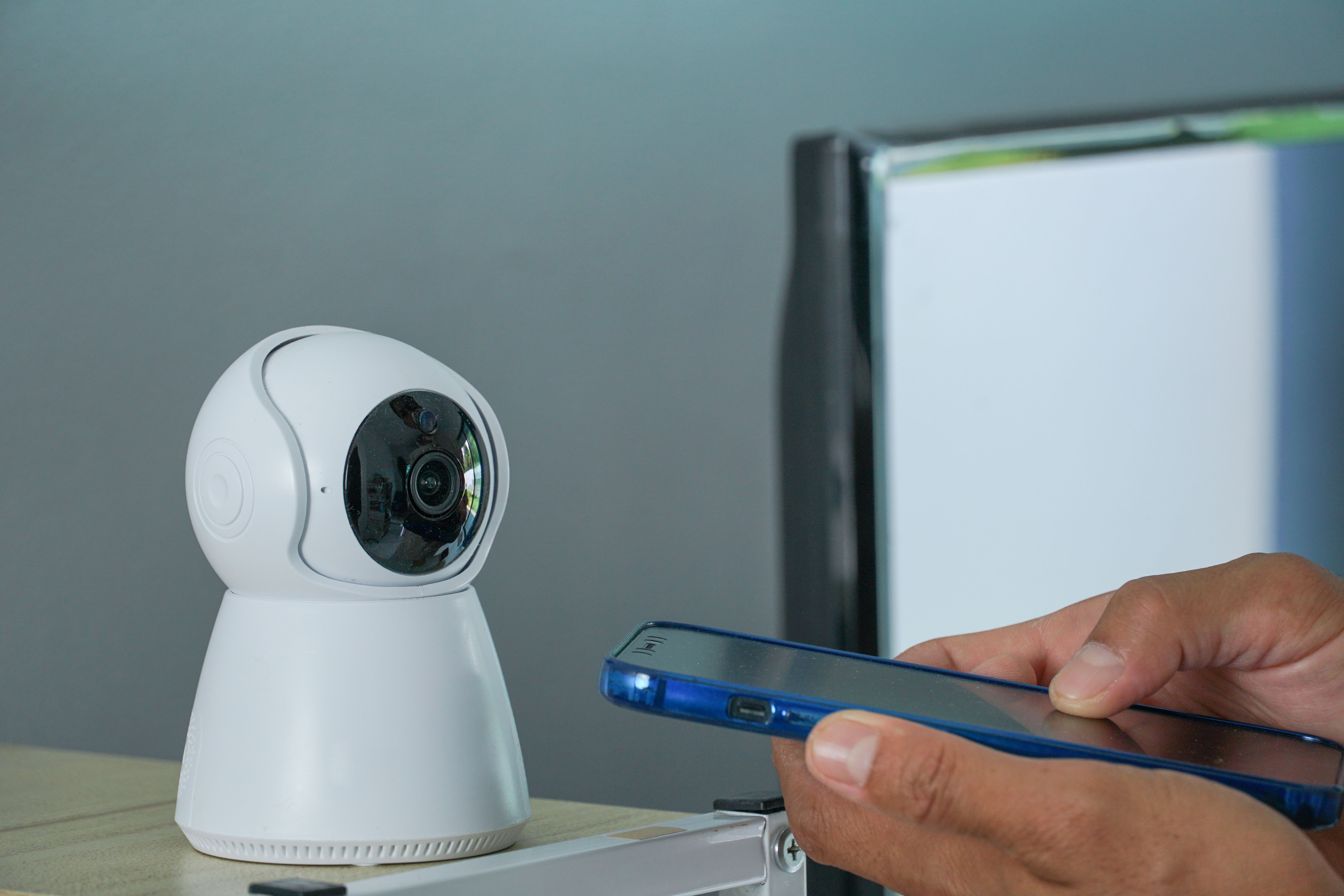 asia men using smart phone connecting to CCTV security at home.