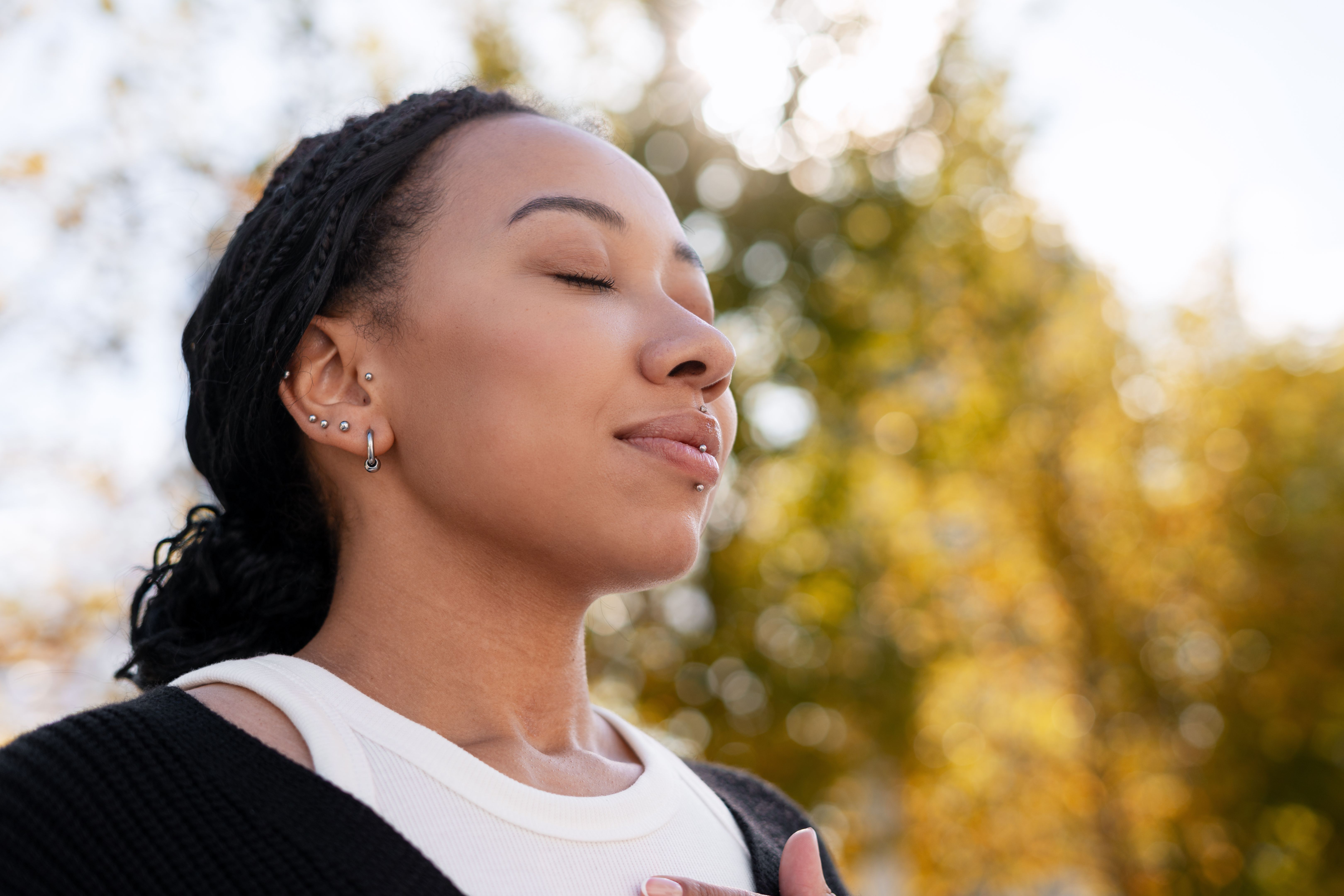 Cheerful African American woman meditating outdoors feeling tranquil breath