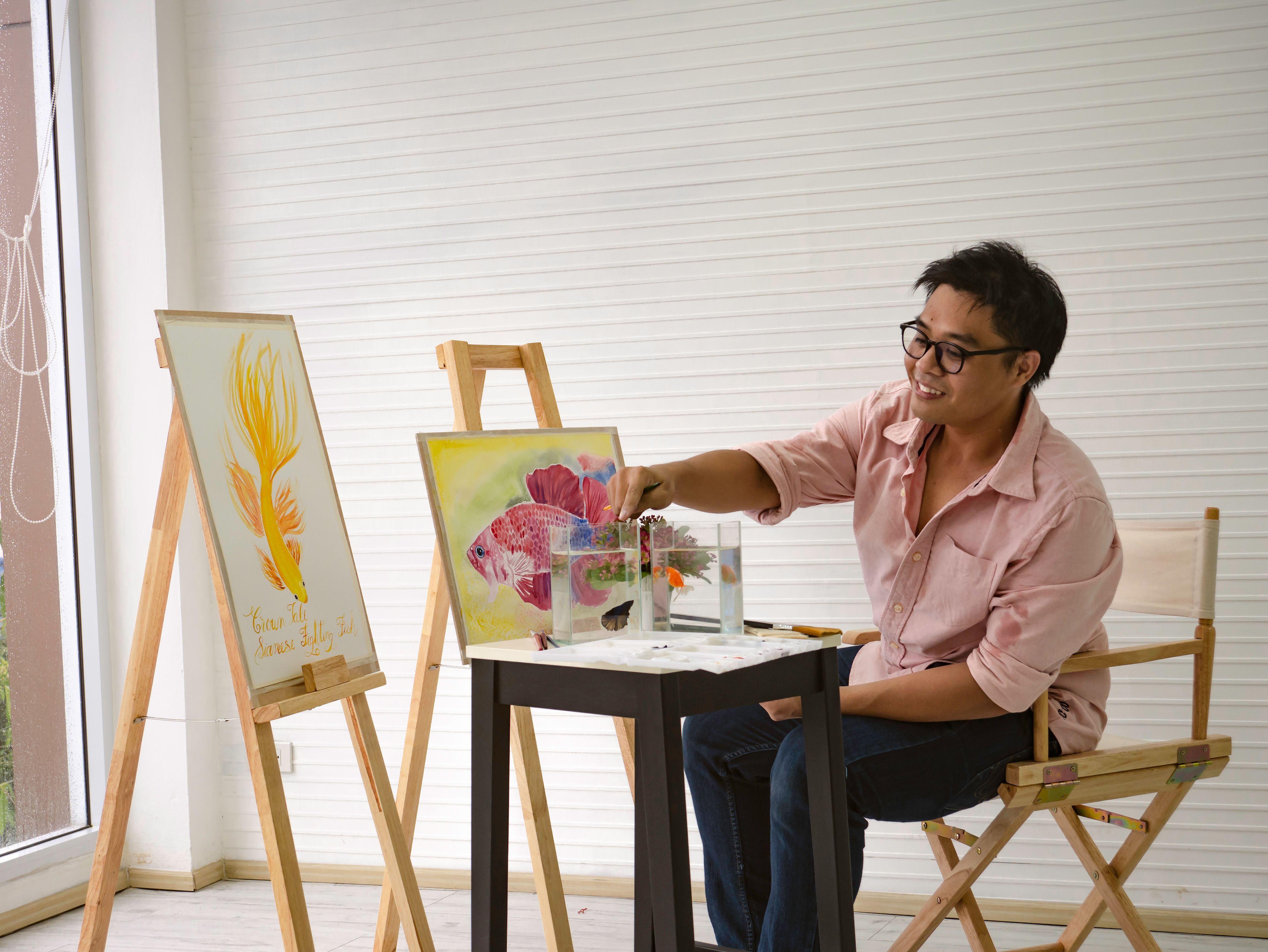 Young adult Male watercolor artist Feeding the fish while drawing the fish paint