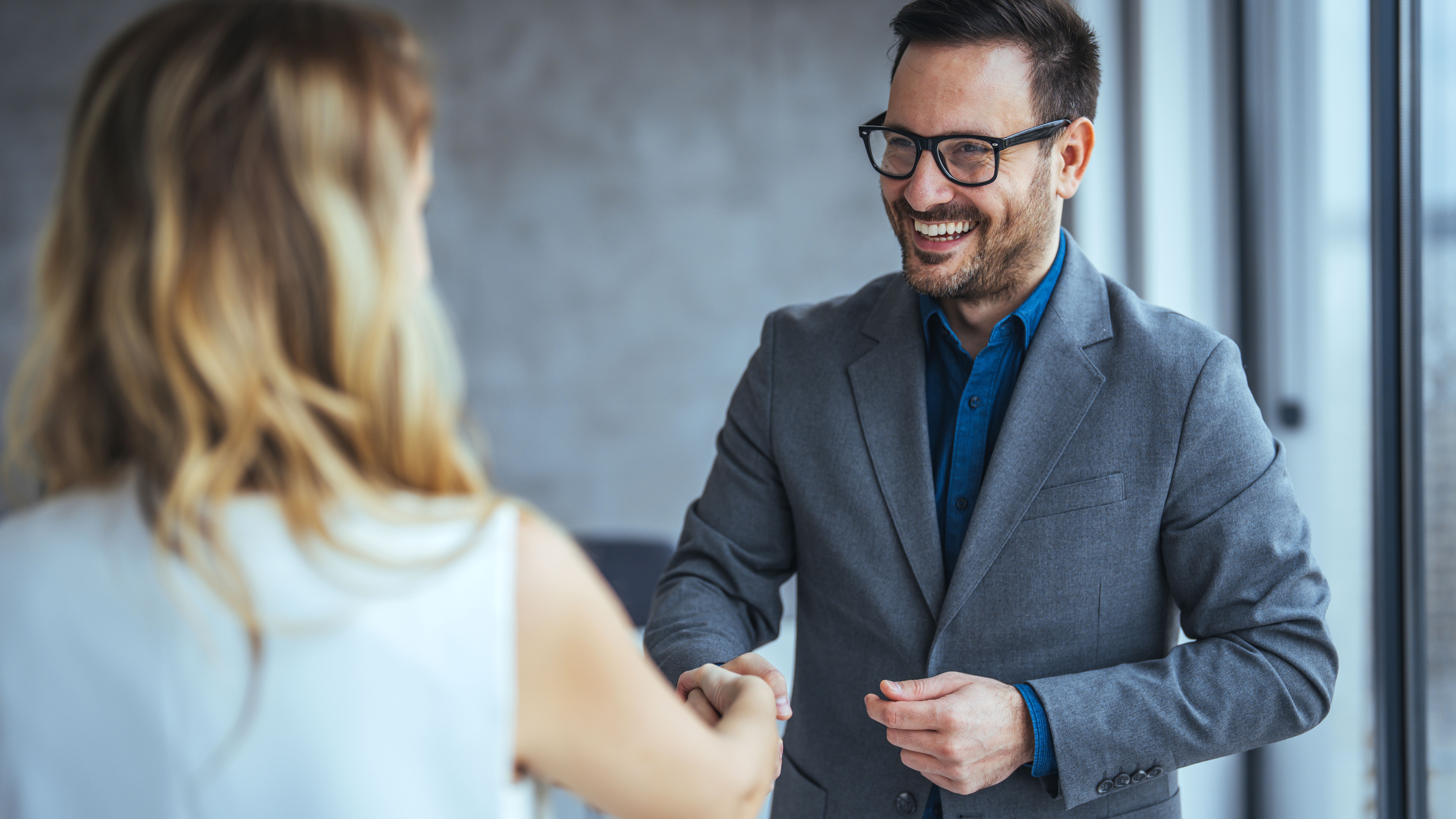 Portrait of cheerful young manager handshake with new employee